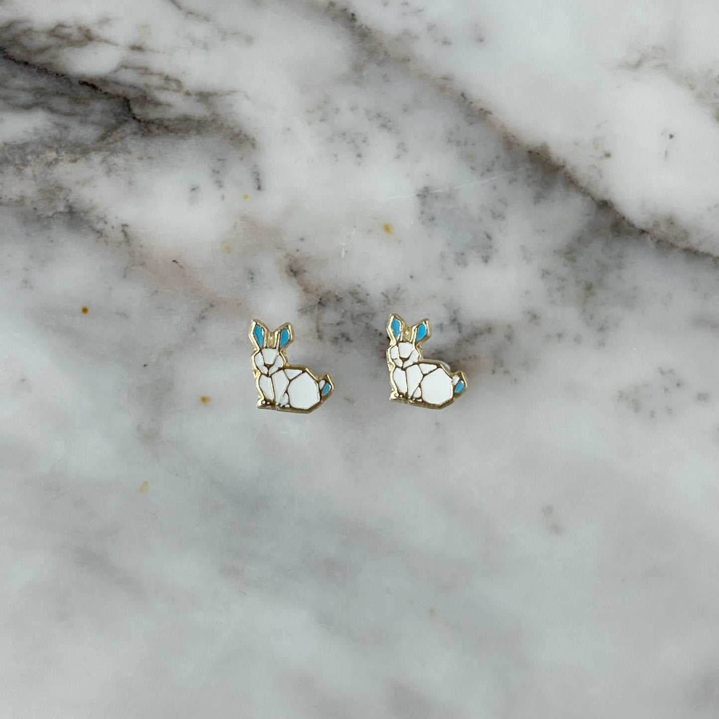 Aretes en oro amarillo 14K con conejo esmaltado blanco y orejas celestes con tope rosca