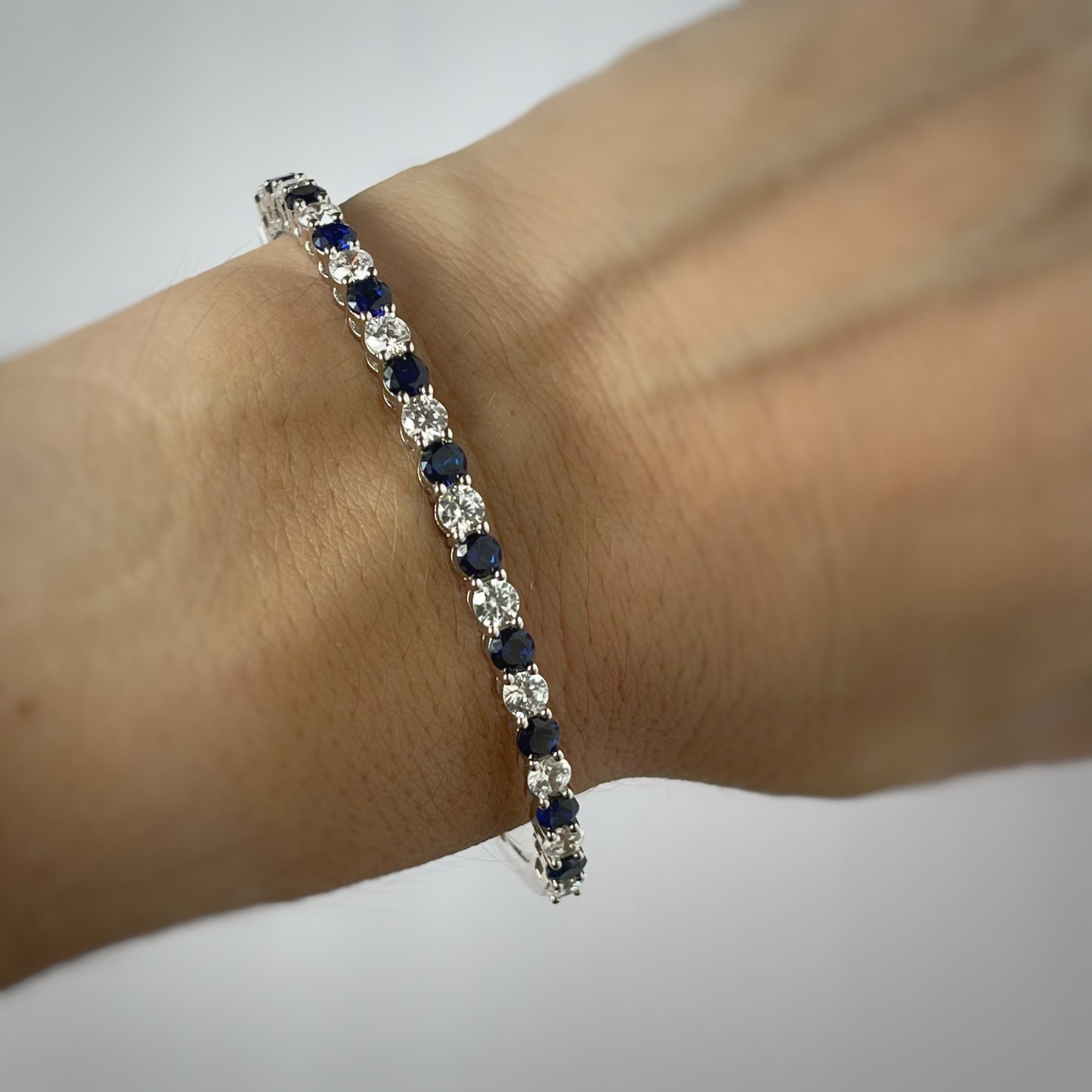 Pulsera dura de plata con baño platino y circonita blancas y azul zafiro