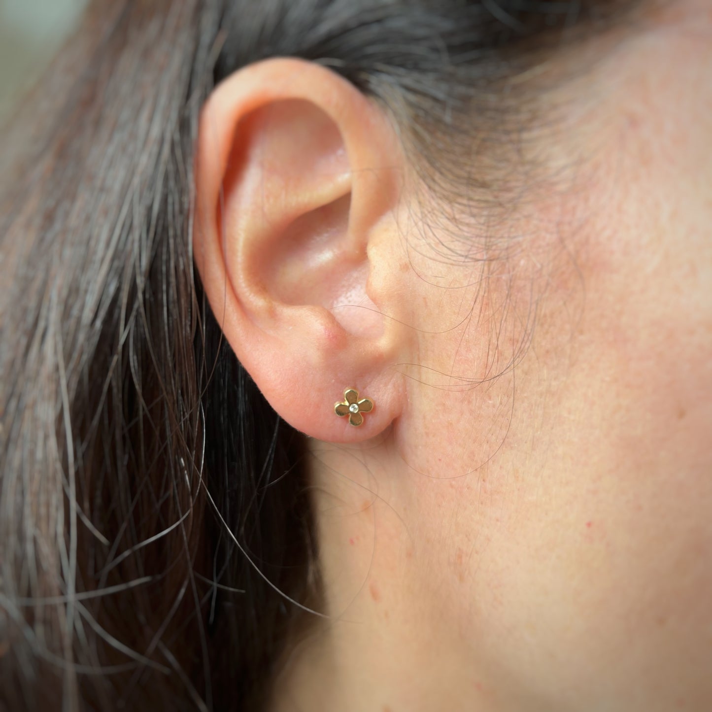 Aretes en oro amarillo de 14k con flor y circonita en el centro con broche rosca
