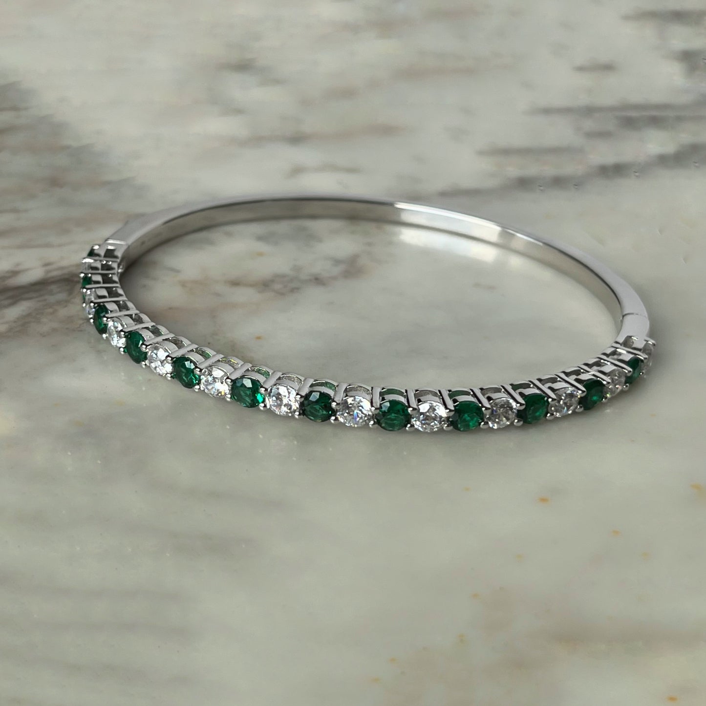 Pulsera dura de plata con baño platino y circonita blancas y verde esmeralda
