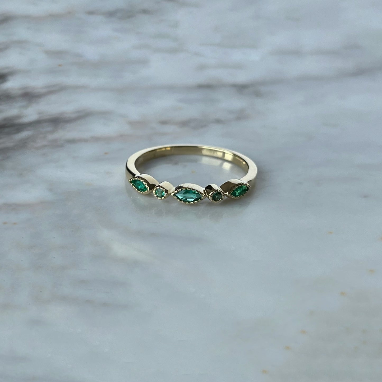Anillo en oro amarillo 10k con esmeralda, marquesas y redondas