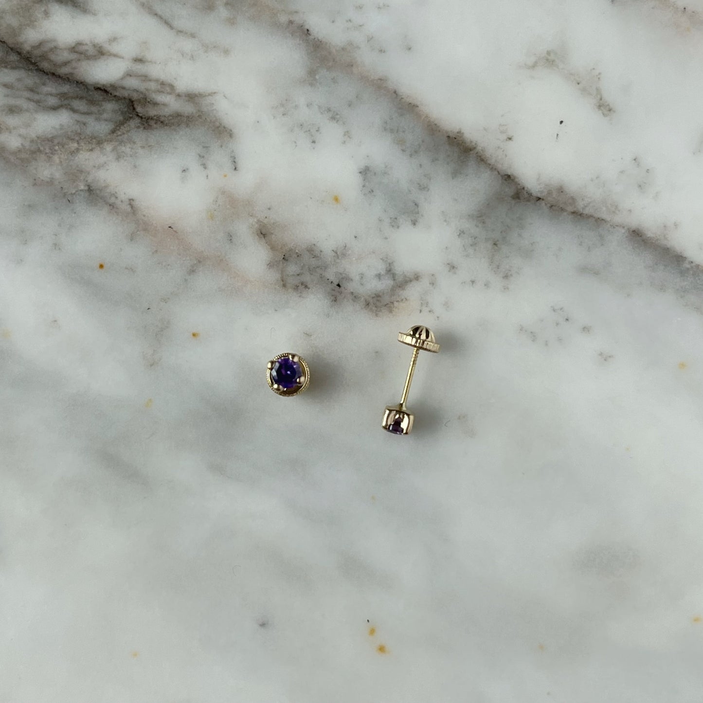 Aretes en oro amarillo 14k con circonita morada con broche rosca