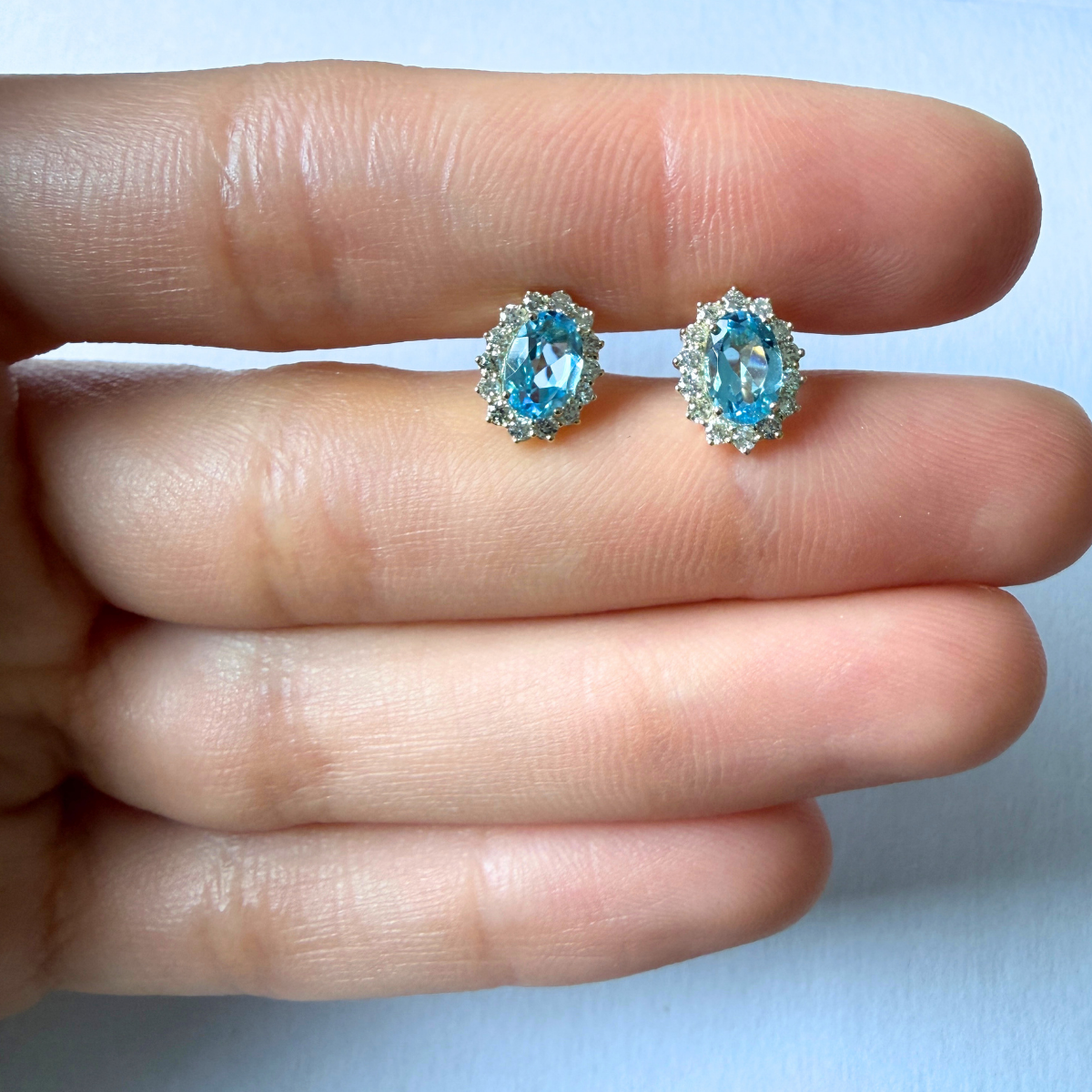 Aretes en oro amarillo 10k con topacios azules ovalados y halo de diamantes 0.35ctw