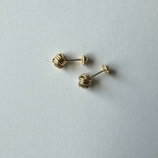 Aretes en oro amarillo 14k con nudo de aro triple y circonita en el centro con tope rosca