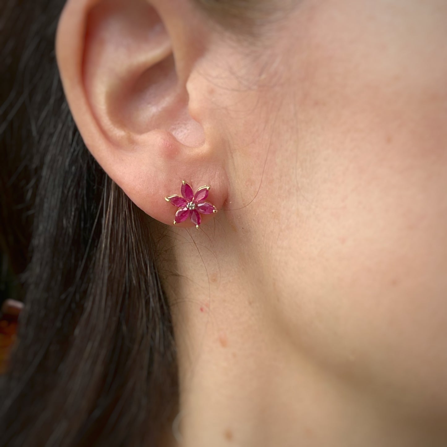 Aretes de flor de seis pétalos en oro amarillo 10K con rubíes y diamantes