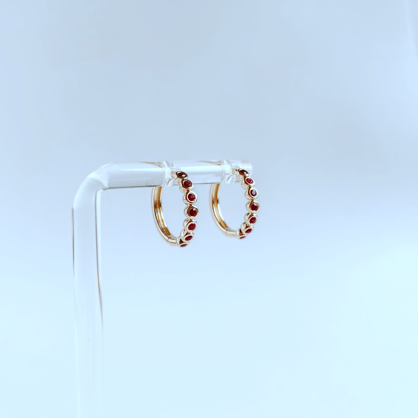 Argollas redondas en oro amarillo 10k con rubíes biselados