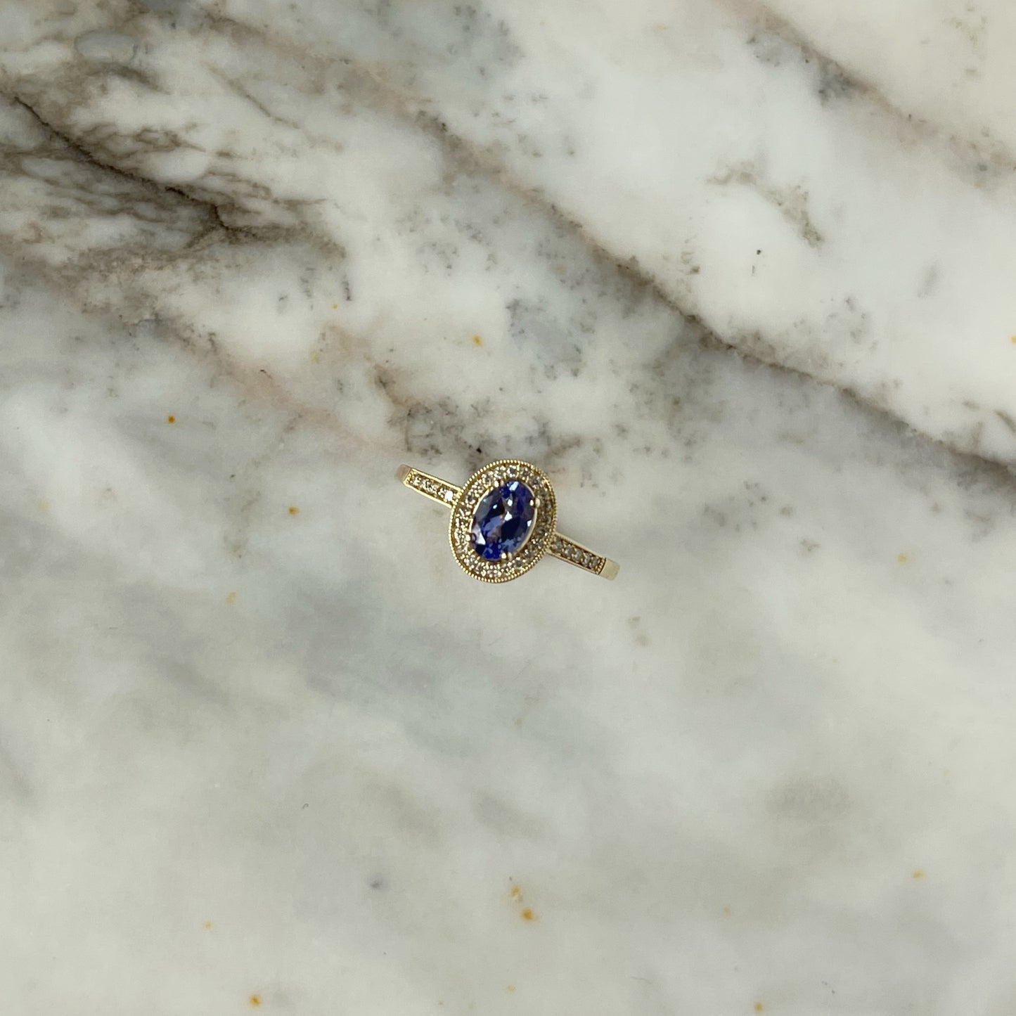 Anillo en oro amarillo 10k con tanzanita ovalada y diamantes 0.12ctw