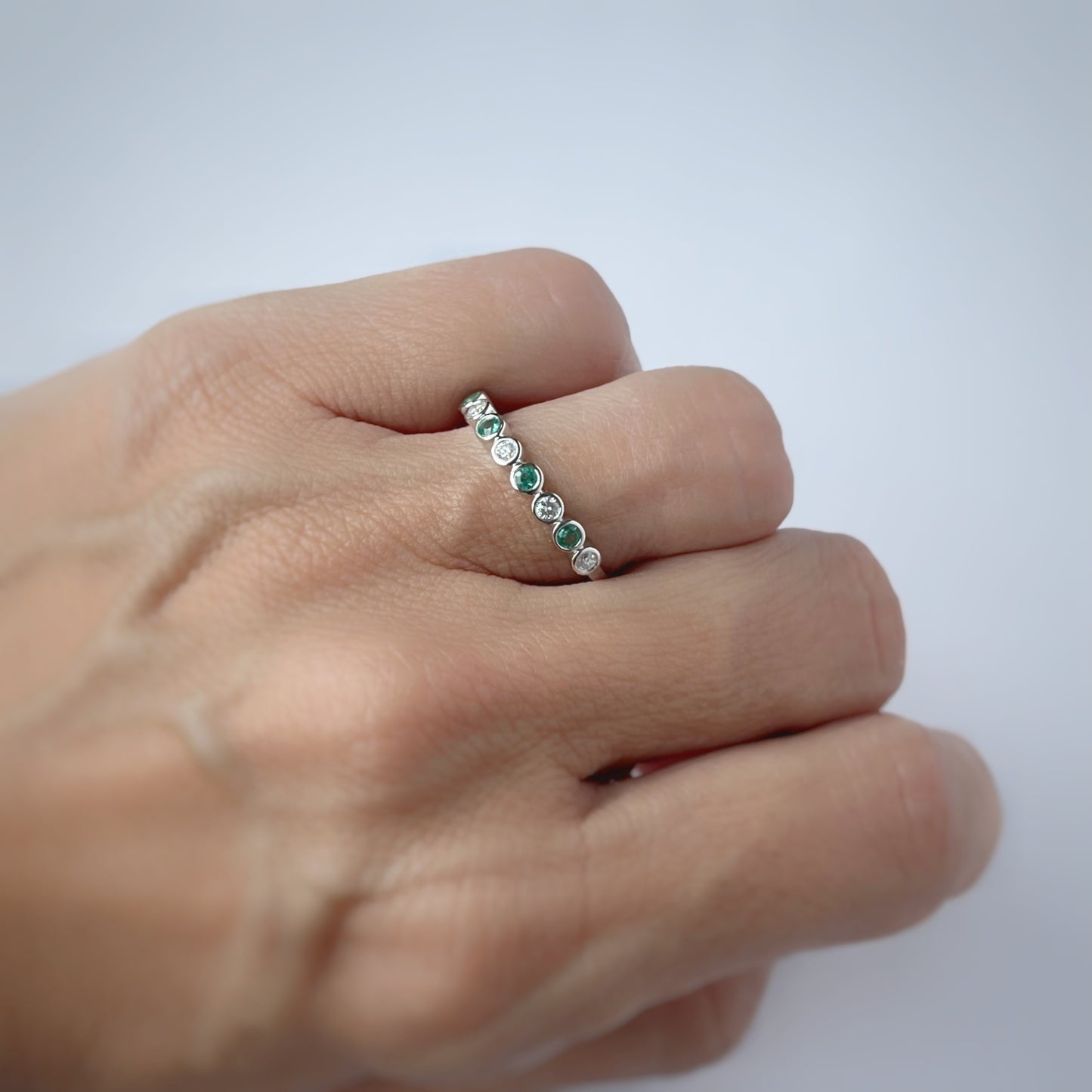 Medio cintillo de diamantes 0.15ctw y esmeraldas biseladas en oro blanco 10k