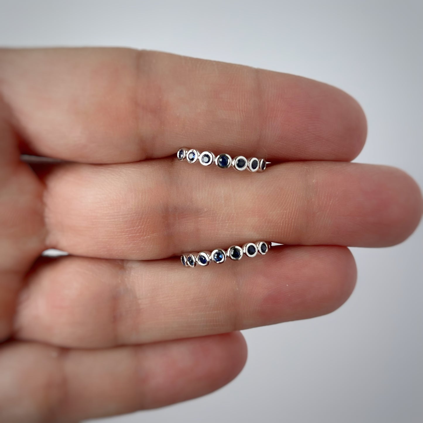 Argollas redondas en oro blanco 10k con zafiros biselados