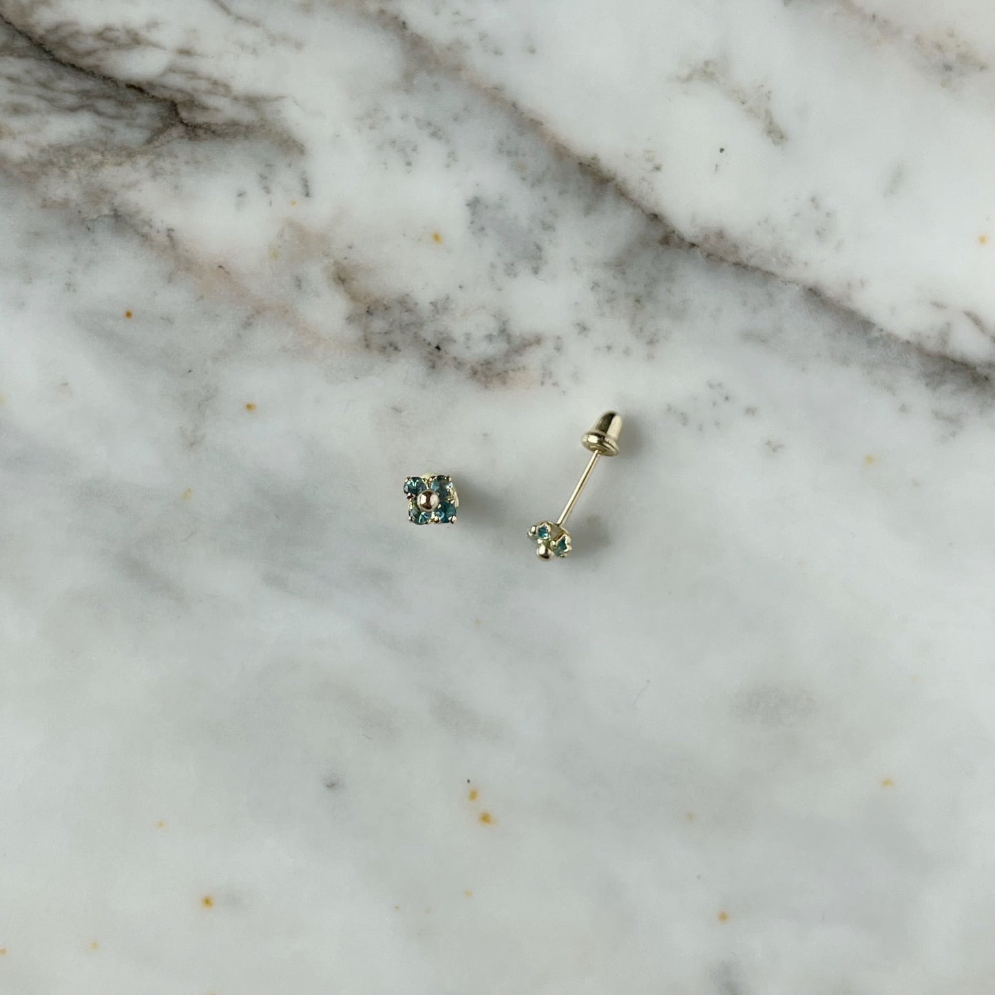 Aretes en oro amarillo 14k flores de circonitas celeste con bolita de oro en el centro con broche rosca