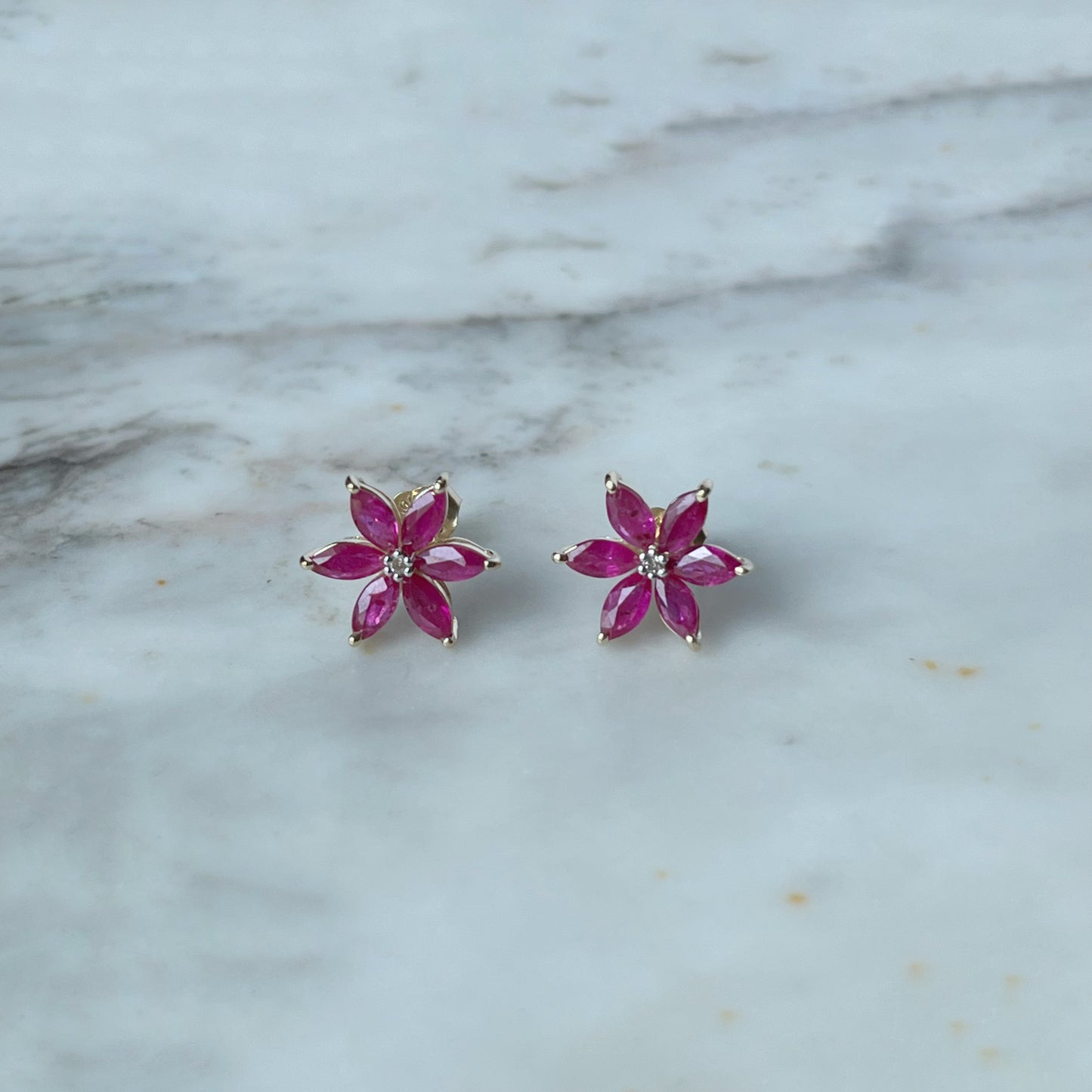 Aretes de flor de seis pétalos en oro amarillo 10K con rubíes y diamantes