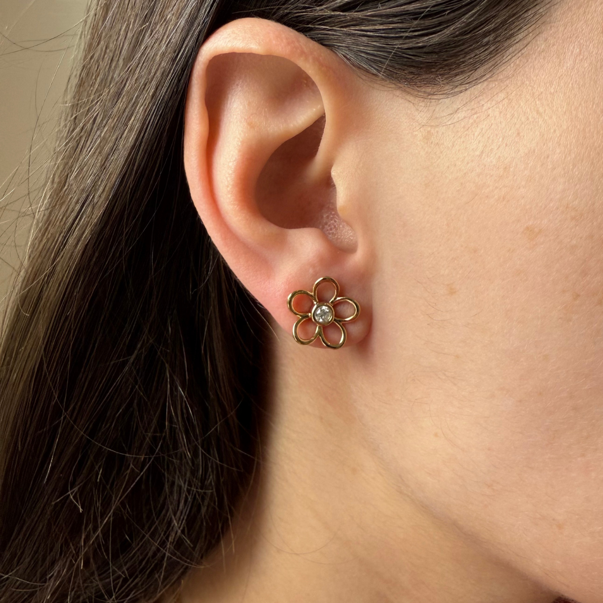 Aretes de flor delineada con diamante central 0.20ctw en plata con baño de oro