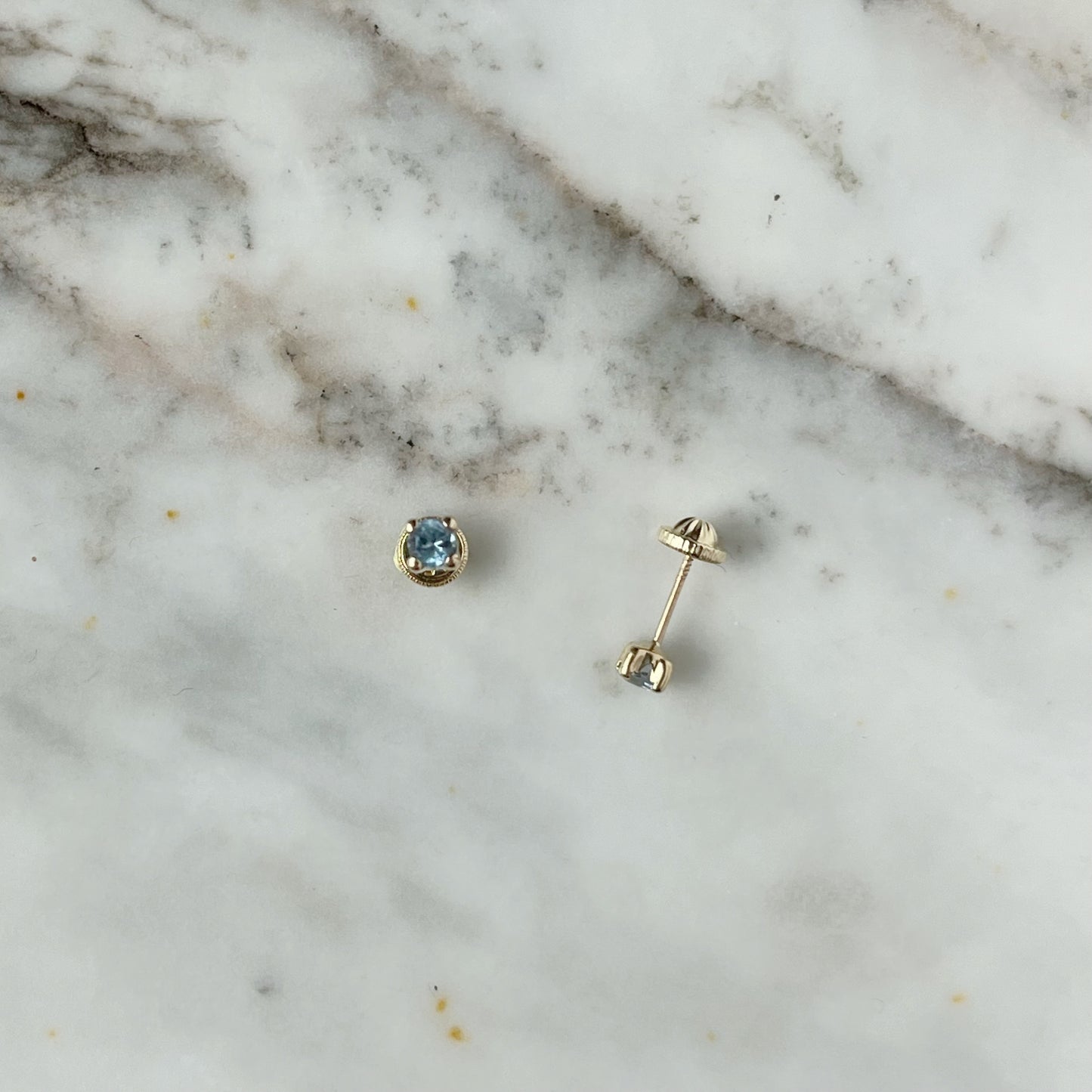 Aretes en oro amarillo 14k con circonita celeste con broche rosca