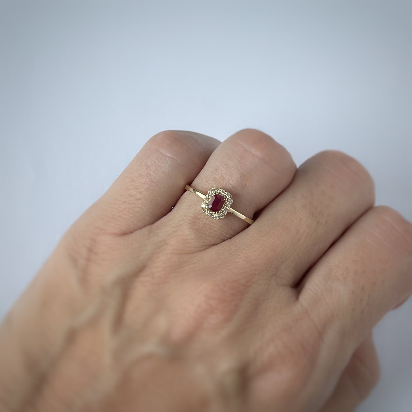 Anillo en oro amarillo 14k con rubí rectangular y halo de diamantes 0.10ctw