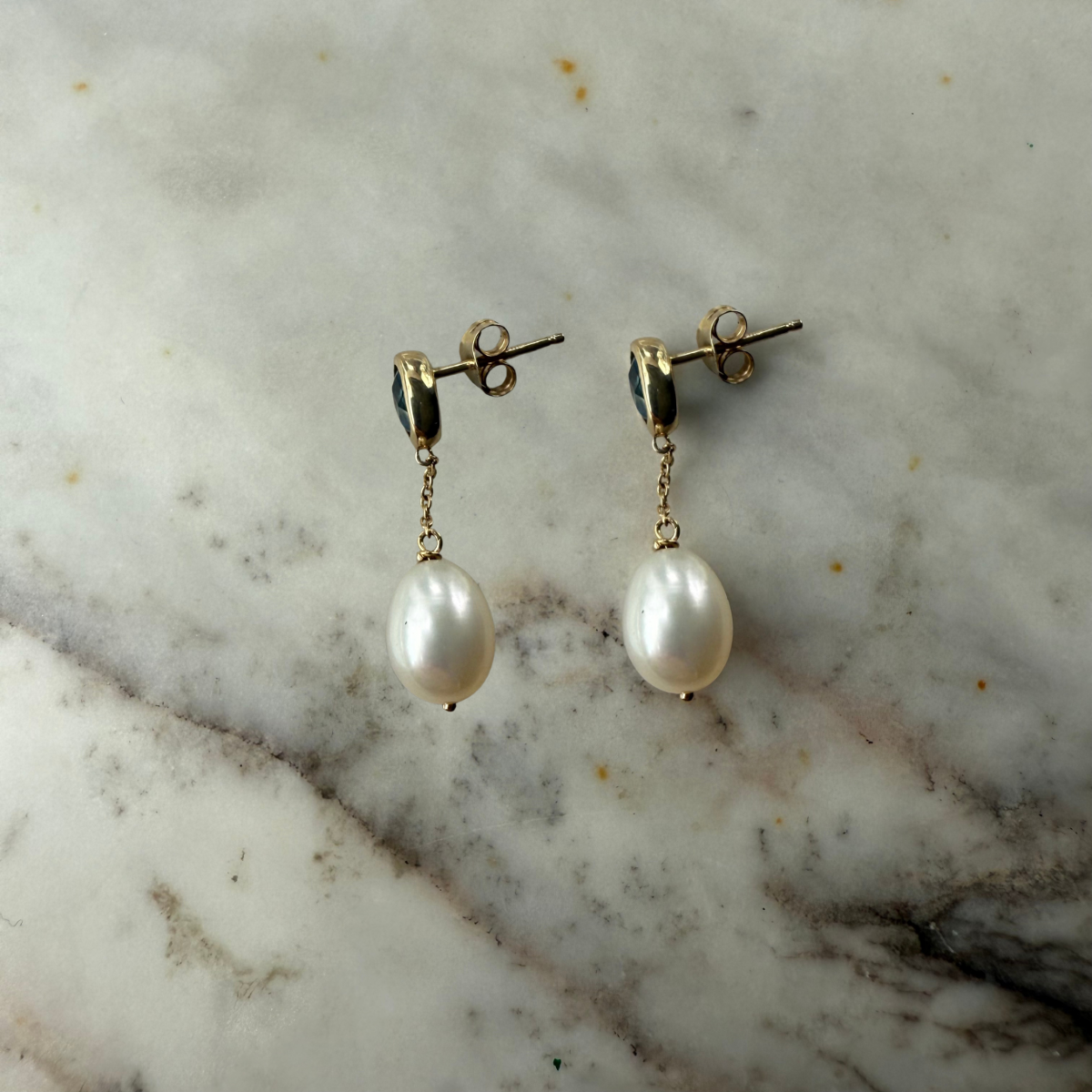 Aretes en oro amarillo 10k con topacio London Blue biselado y perla colgante