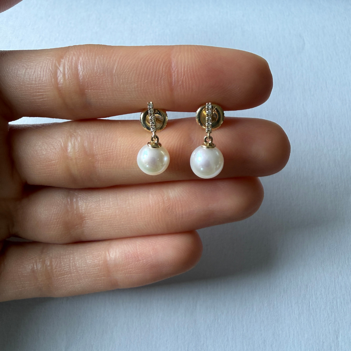 Aretes en oro amarillo 10k con barrita de diamantes 0.06ctw y perla colgante con broche a rosca