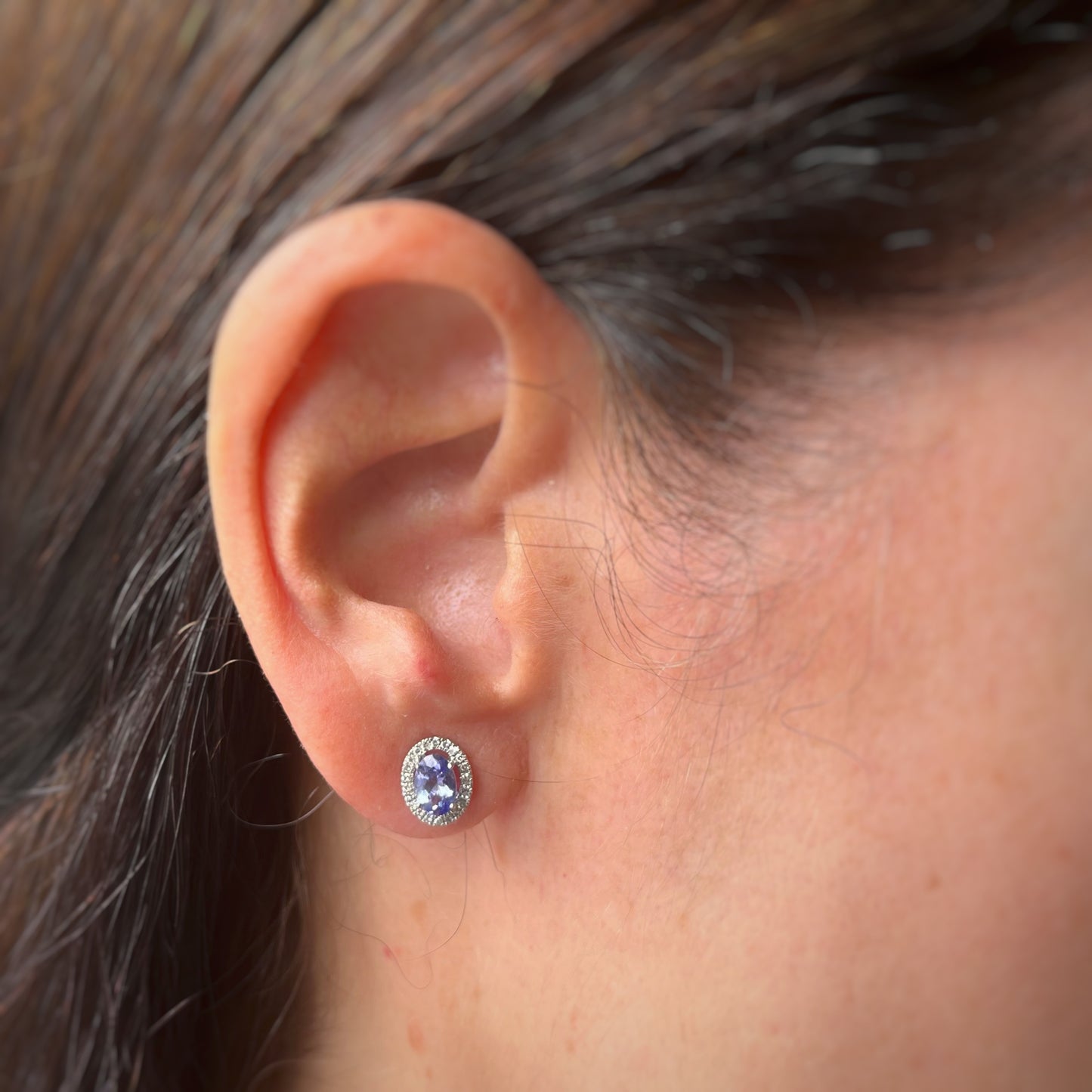 Aretes en oro blanco 10k con tanzanita ovalada y halo de diamantes 0.18ctw con tope rosca