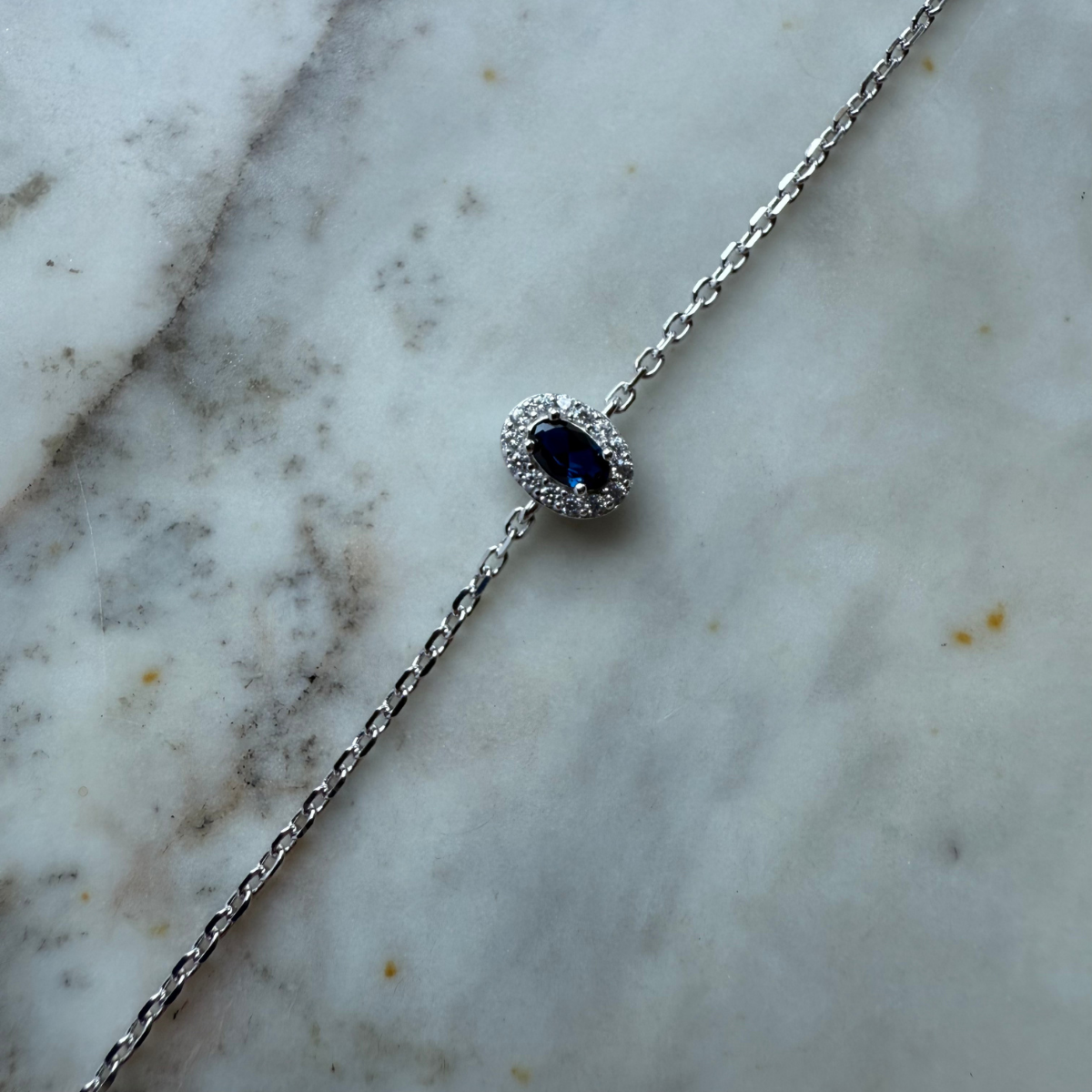 Pulsera de plata con circonita azul ovalada y halo de circonitas blancas