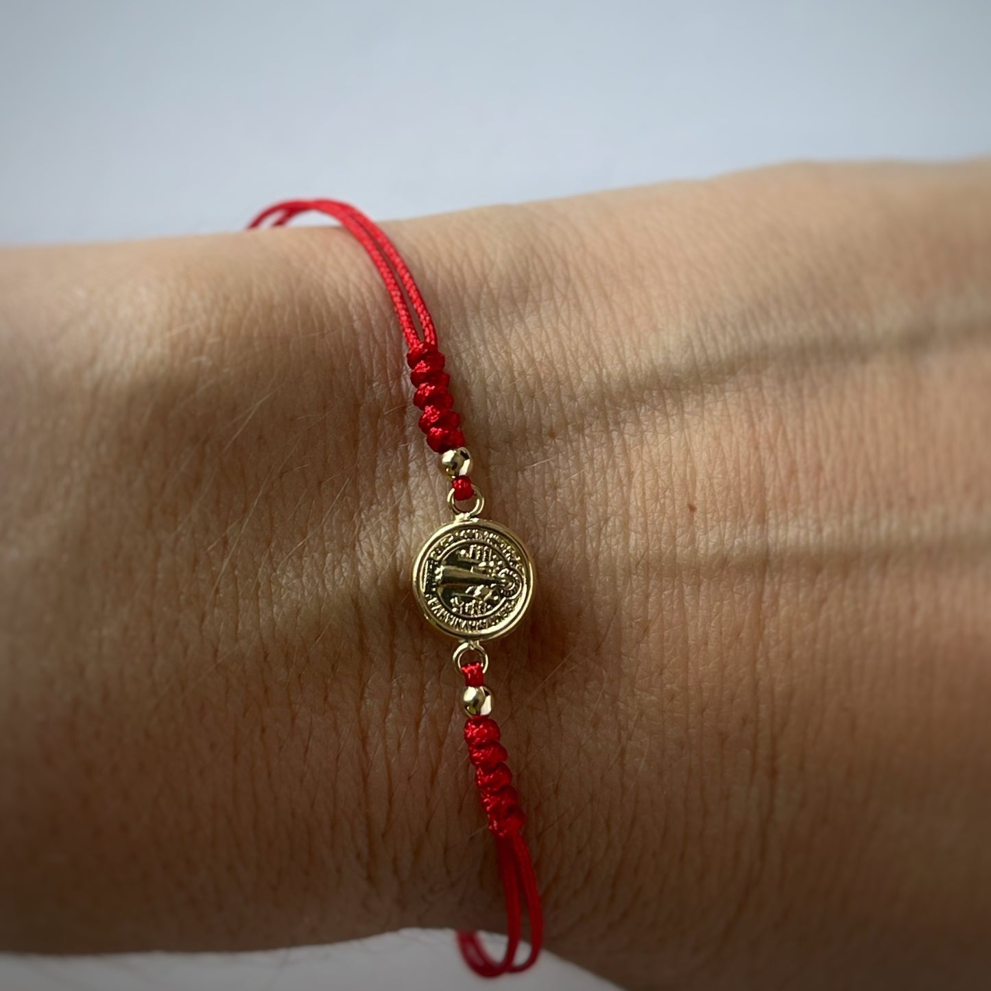 Pulsera de San benito en oro amarillo de 14K con cordón rojo