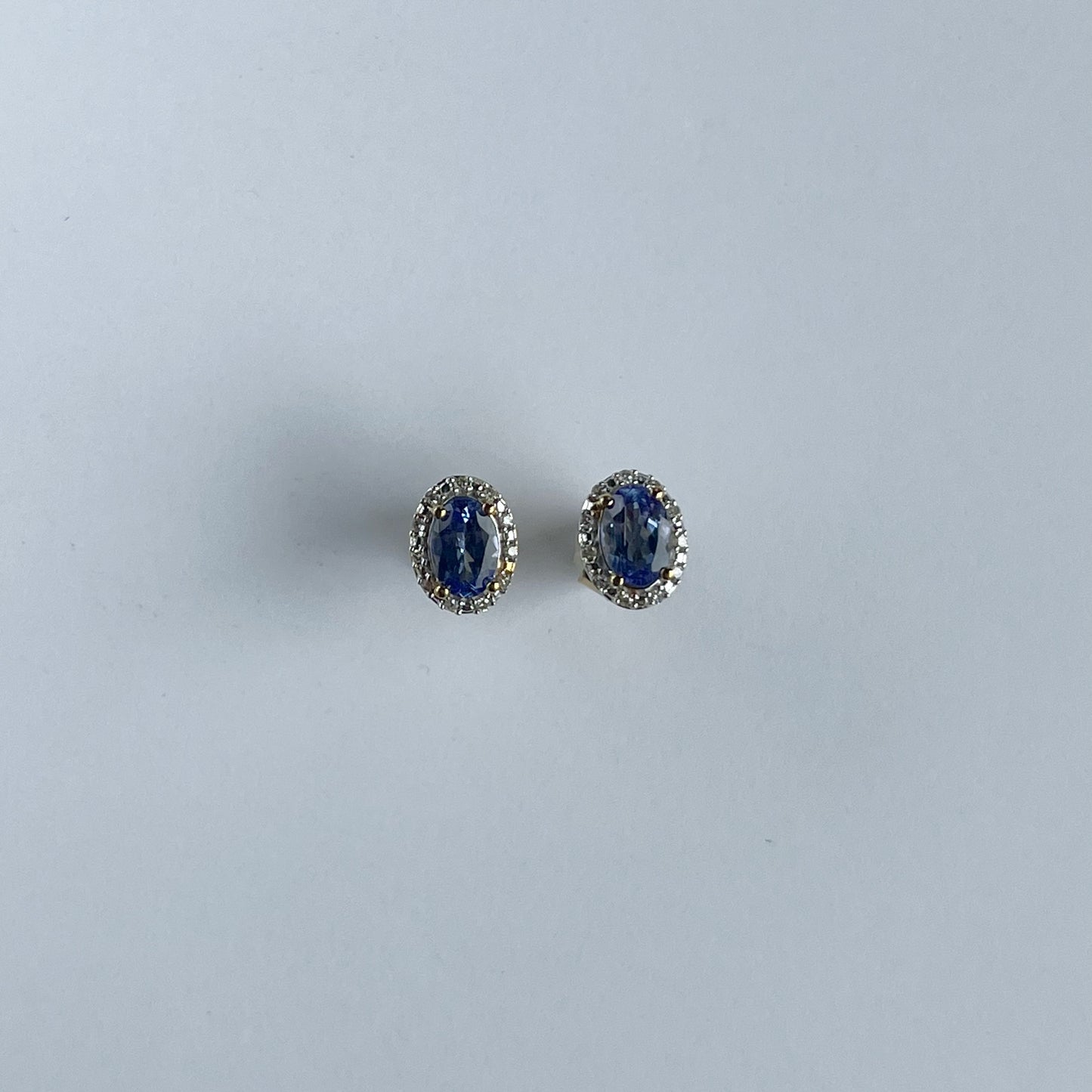 Aretes en oro amarillo 10k con tanzanita ovalada y halo de diamantes