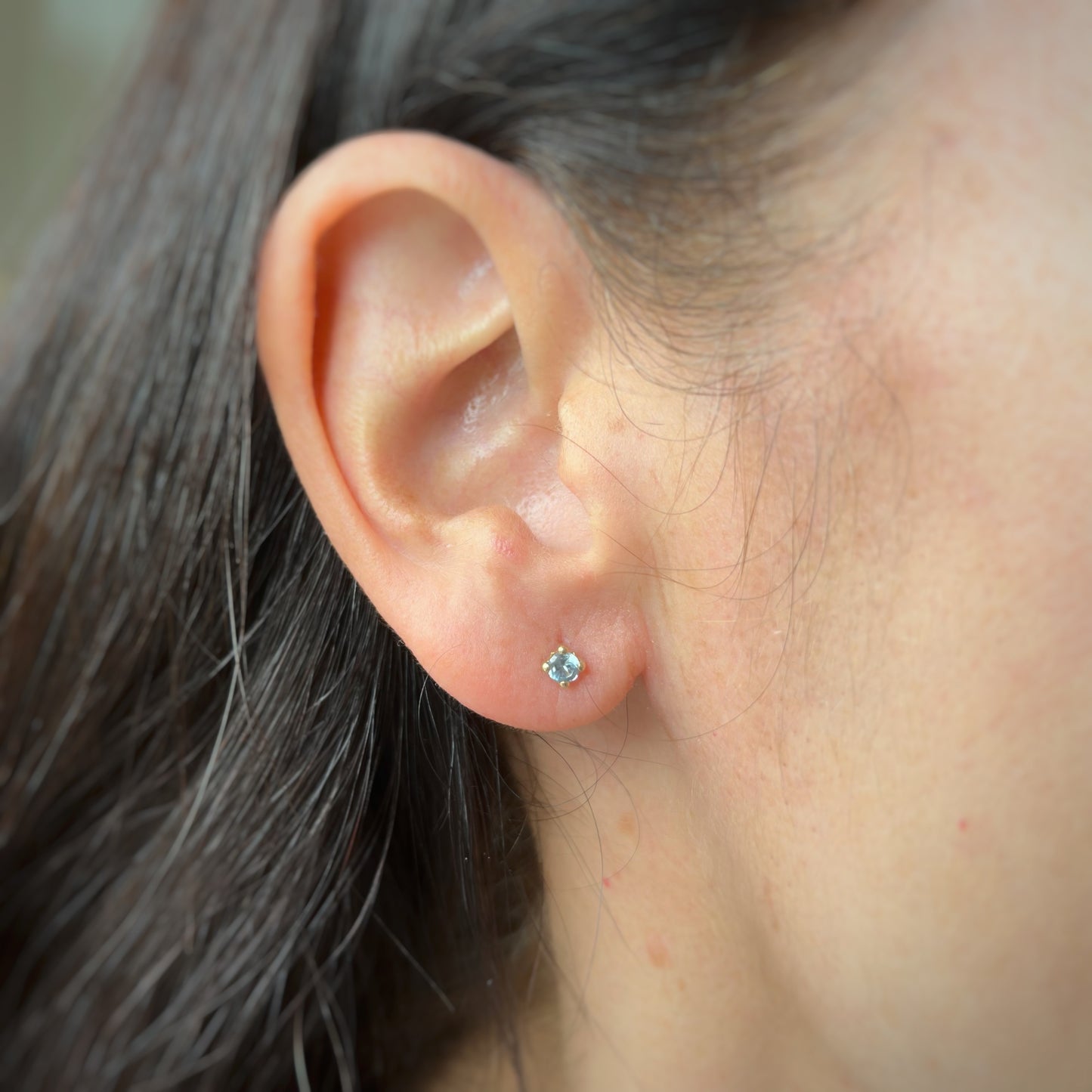 Aretes en oro amarillo 14k con circonita celeste con broche rosca