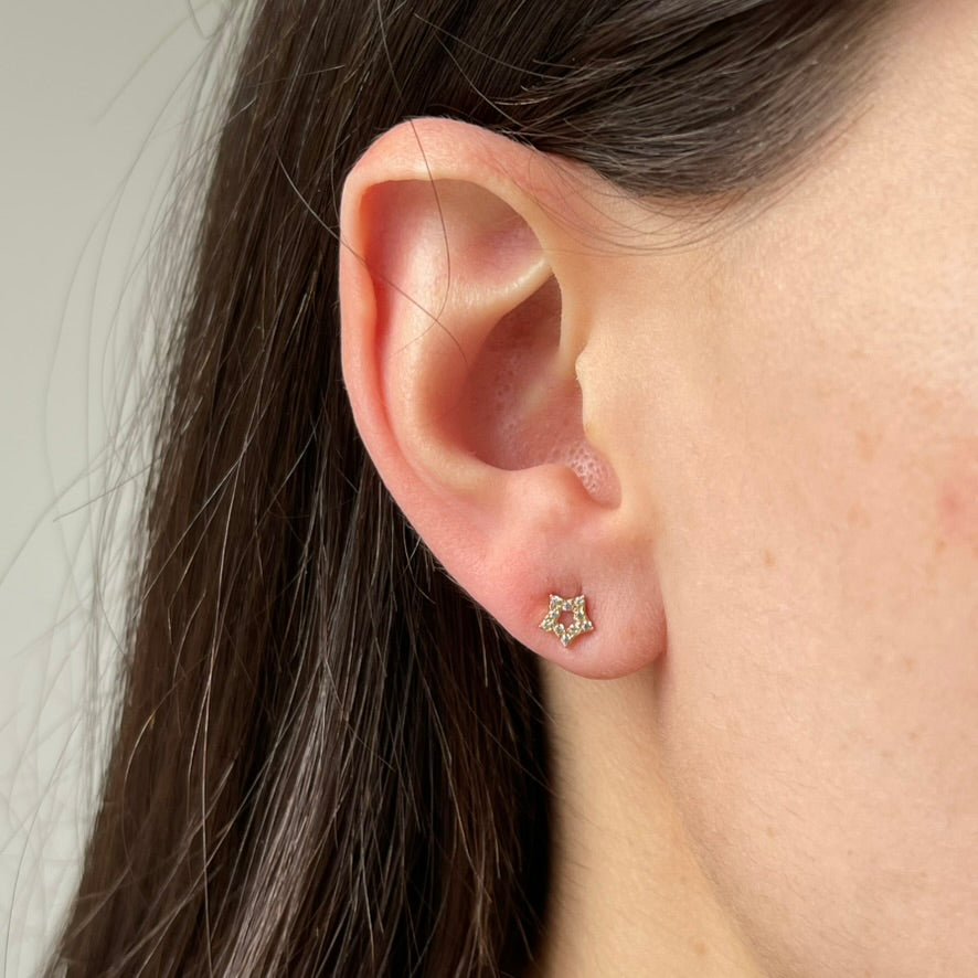 Arete en oro amarilo 14k con estrellita delineada de circonitas con tope rosca