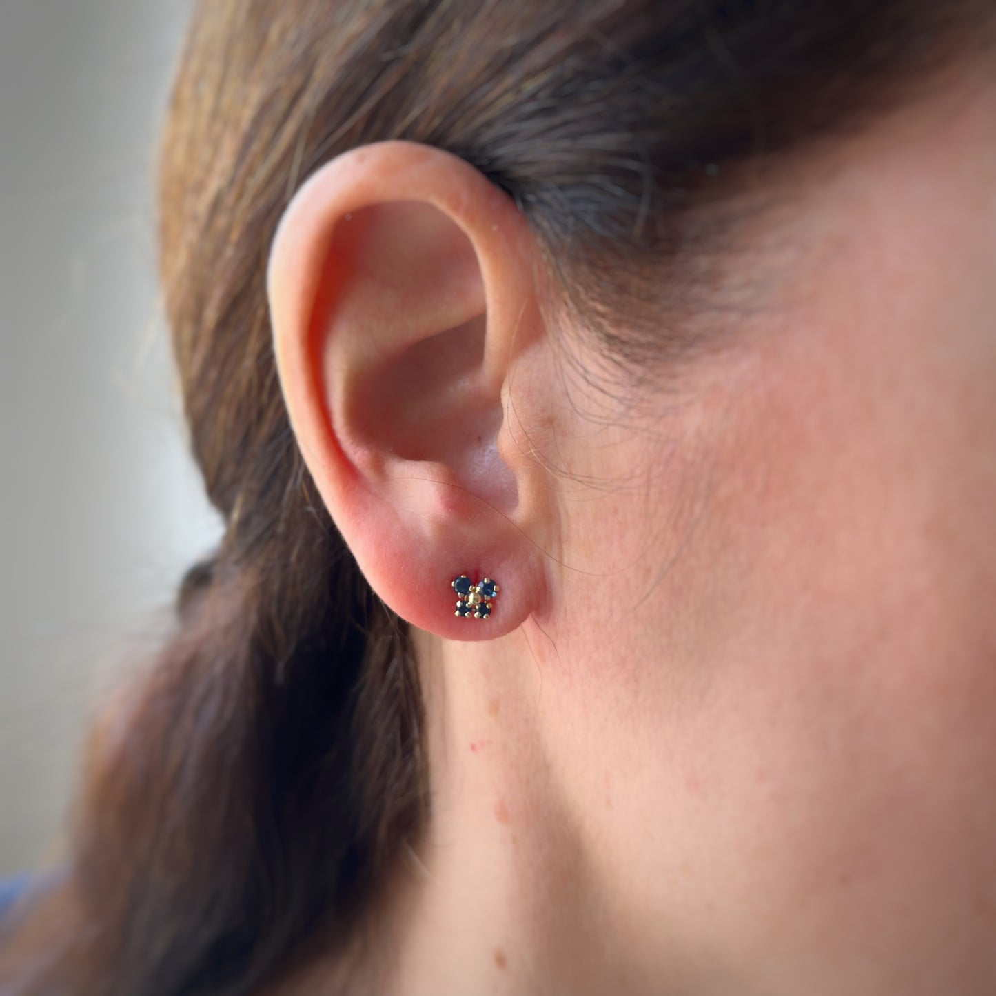 Aretes en oro amarillo 14K con mariposa con circonita azul y bolita de oro en el centro con tope rosca