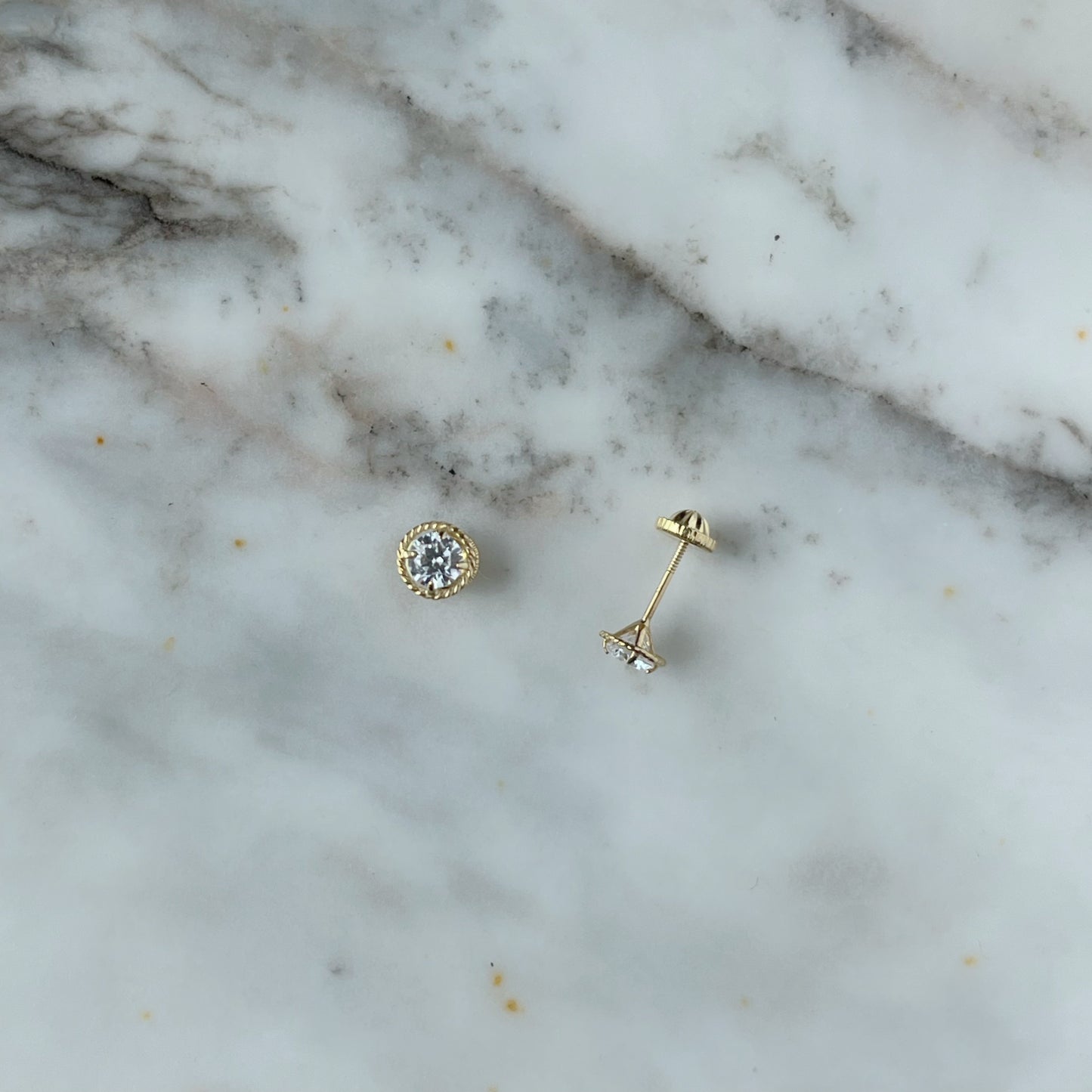 Aretes en oro amarillo 18k con circonita blanca y borde trenzado con broche rosca