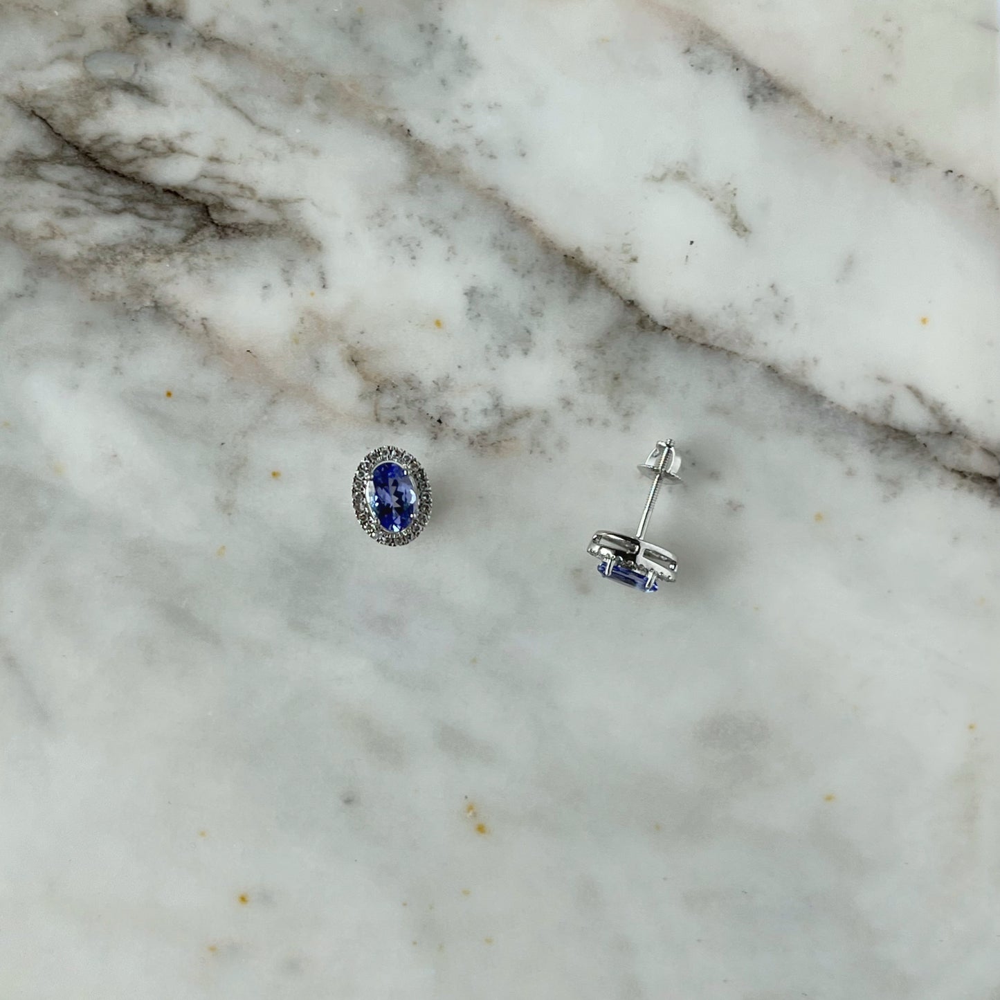 Aretes en oro blanco 10k con tanzanita ovalada y halo de diamantes 0.18ctw con tope rosca