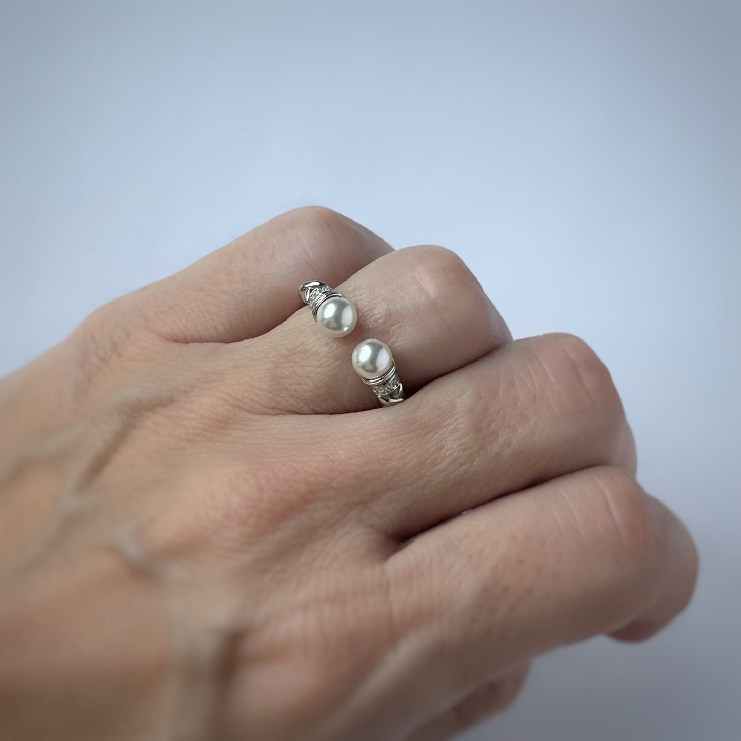 Anillo abierto en plata con baño de platino, perlas de cristal y circonitas