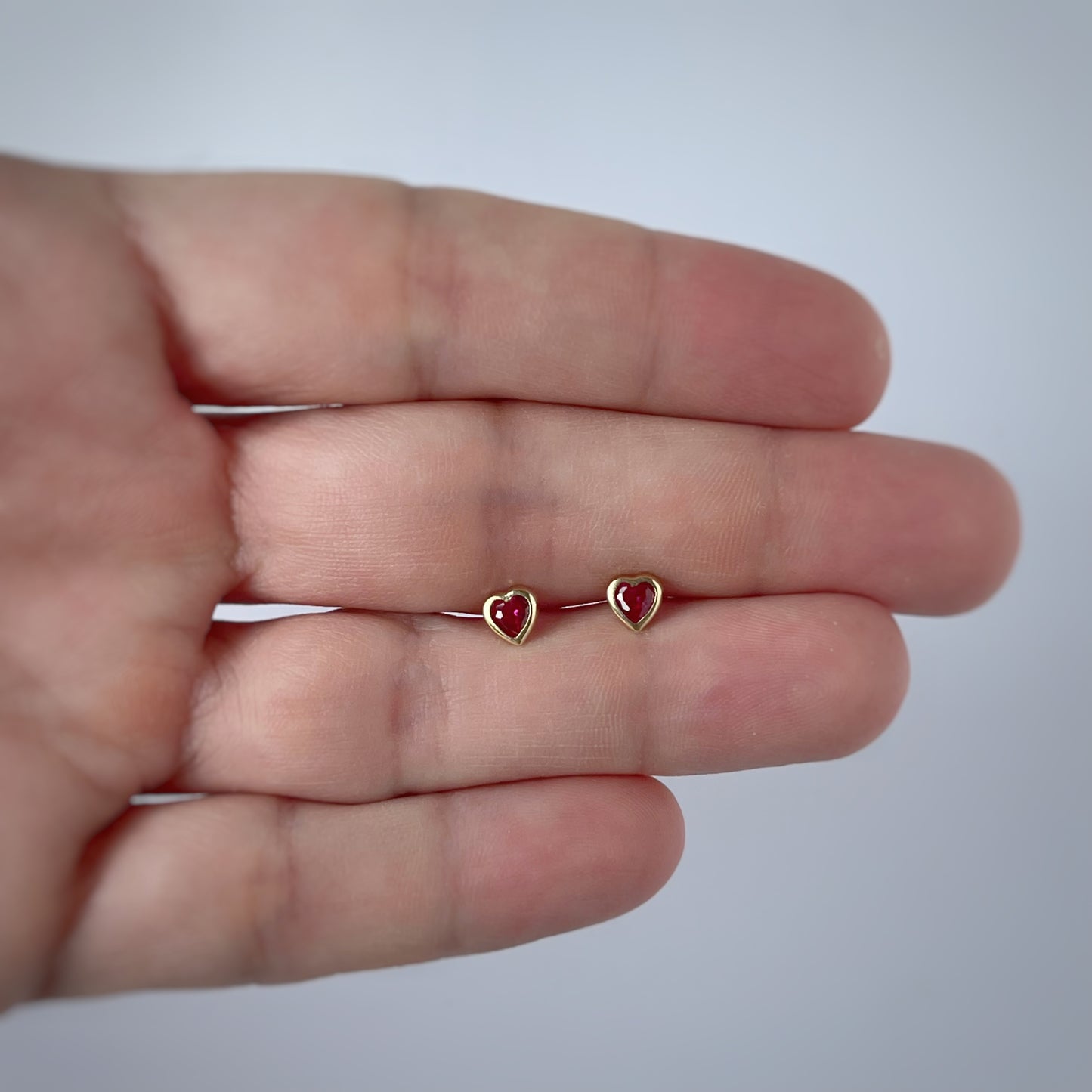 Aretes en oro amarillo 14k circonita roja de corazón con bisel con broche rosca