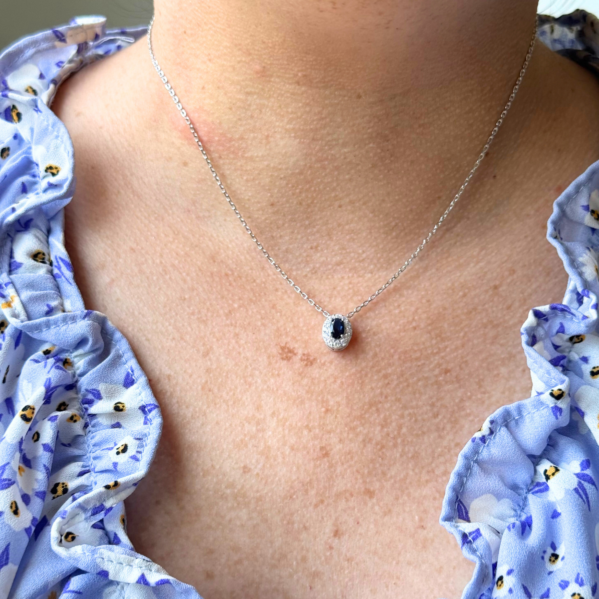 Collar de plata con baño platino y circonita ovalada azul con halo de circonitas blancas