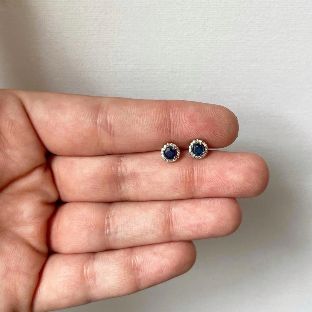 Aretes redondos en oro blanco 10k con zafiros y halo de diamantes 0.10ctw