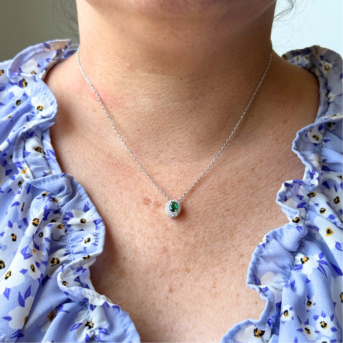 Collar de plata con baño platino y circonita ovalada verde con halo de circonitas blancas.