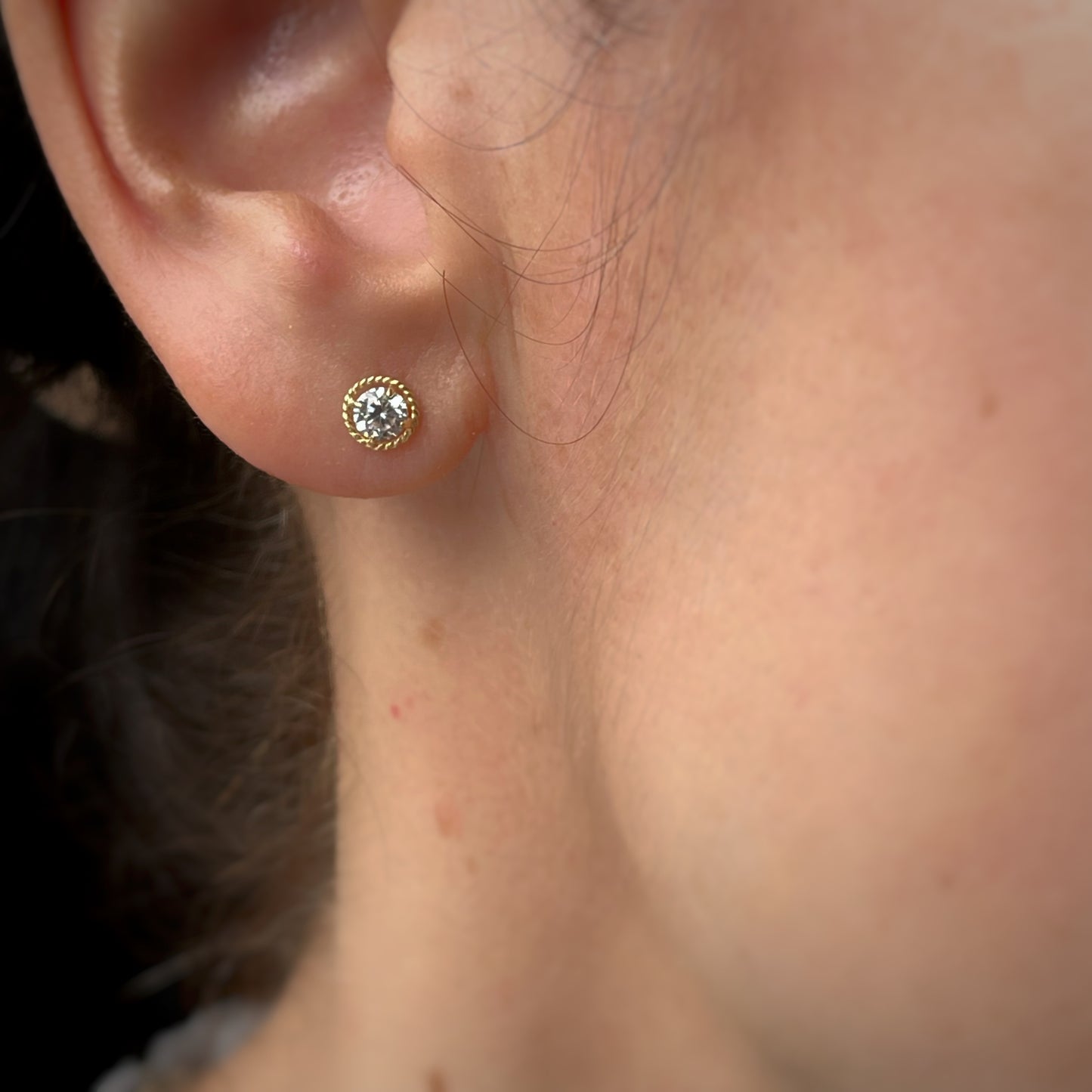 Aretes en oro amarillo 18k con circonita blanca y borde trenzado con broche rosca