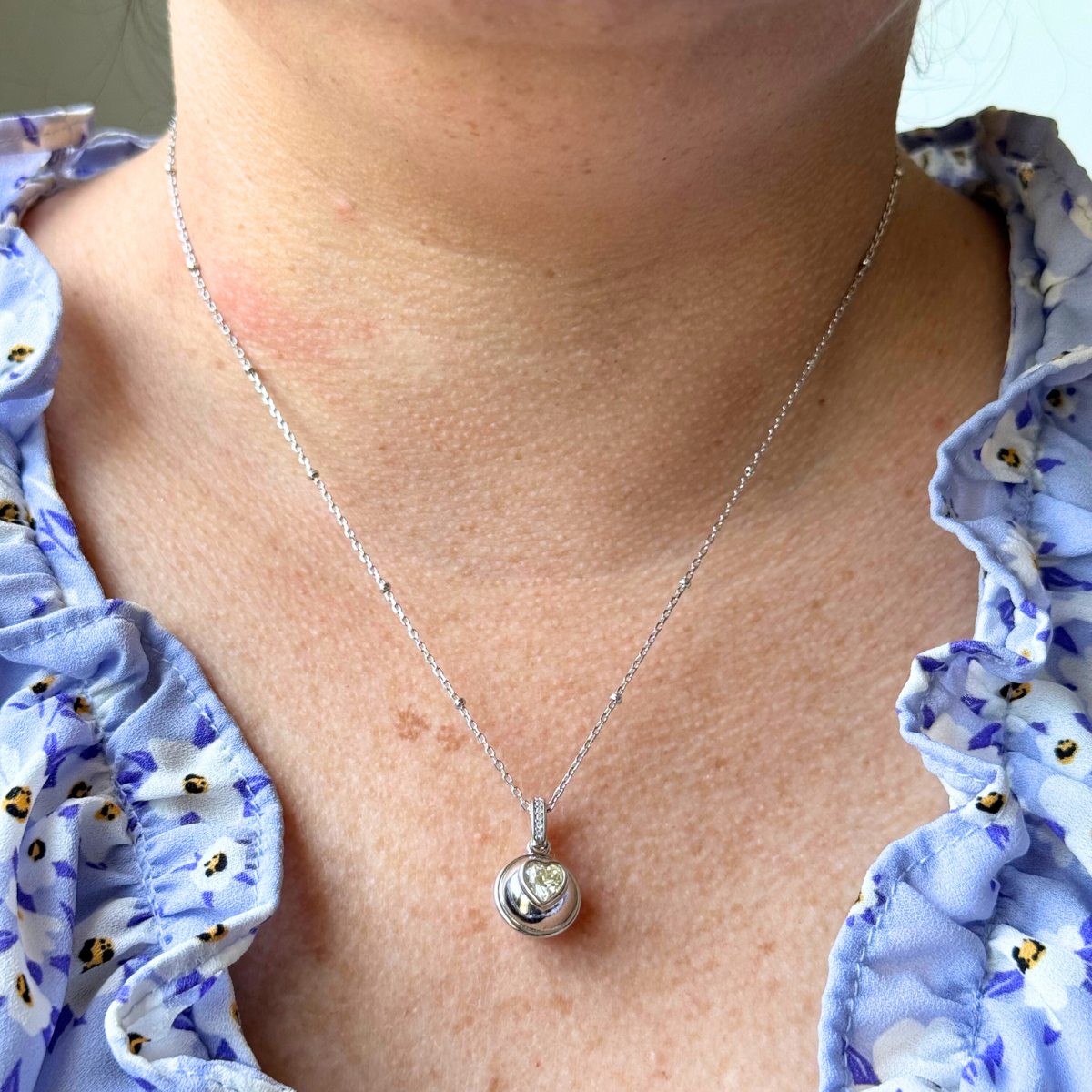 Collar de plata con baño de platino y dije bolita con corazón de circonita amarilla