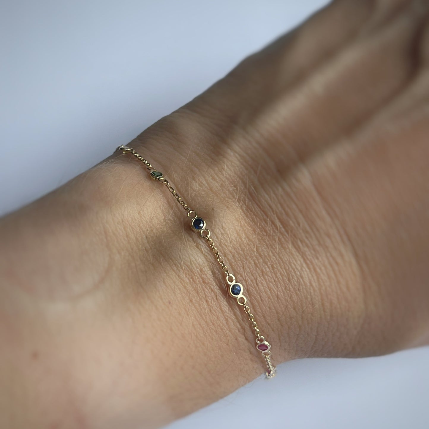 Pulsera en oro amarillo 14k con estaciones de piedras naturales en los colores del arcoíris