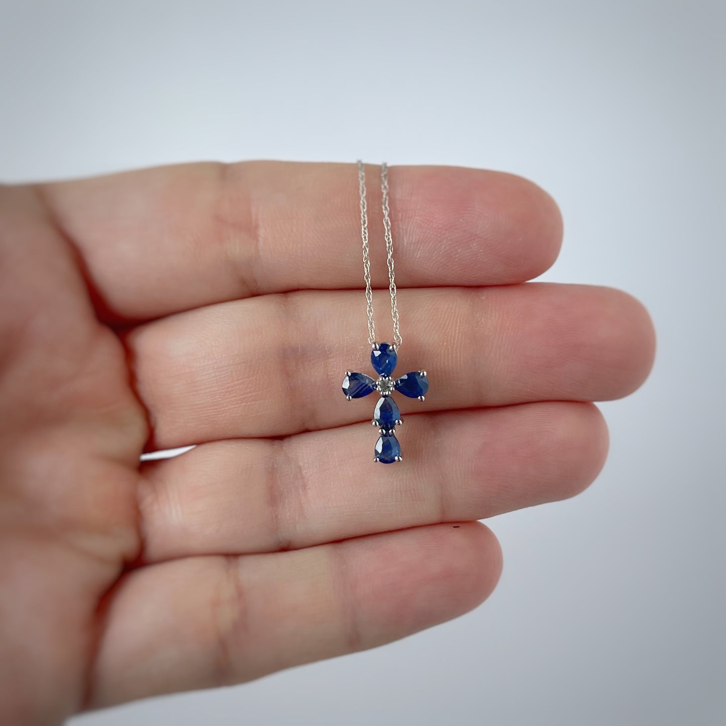 Collar con cruz en oro blanco 14k con zafiros y diamante