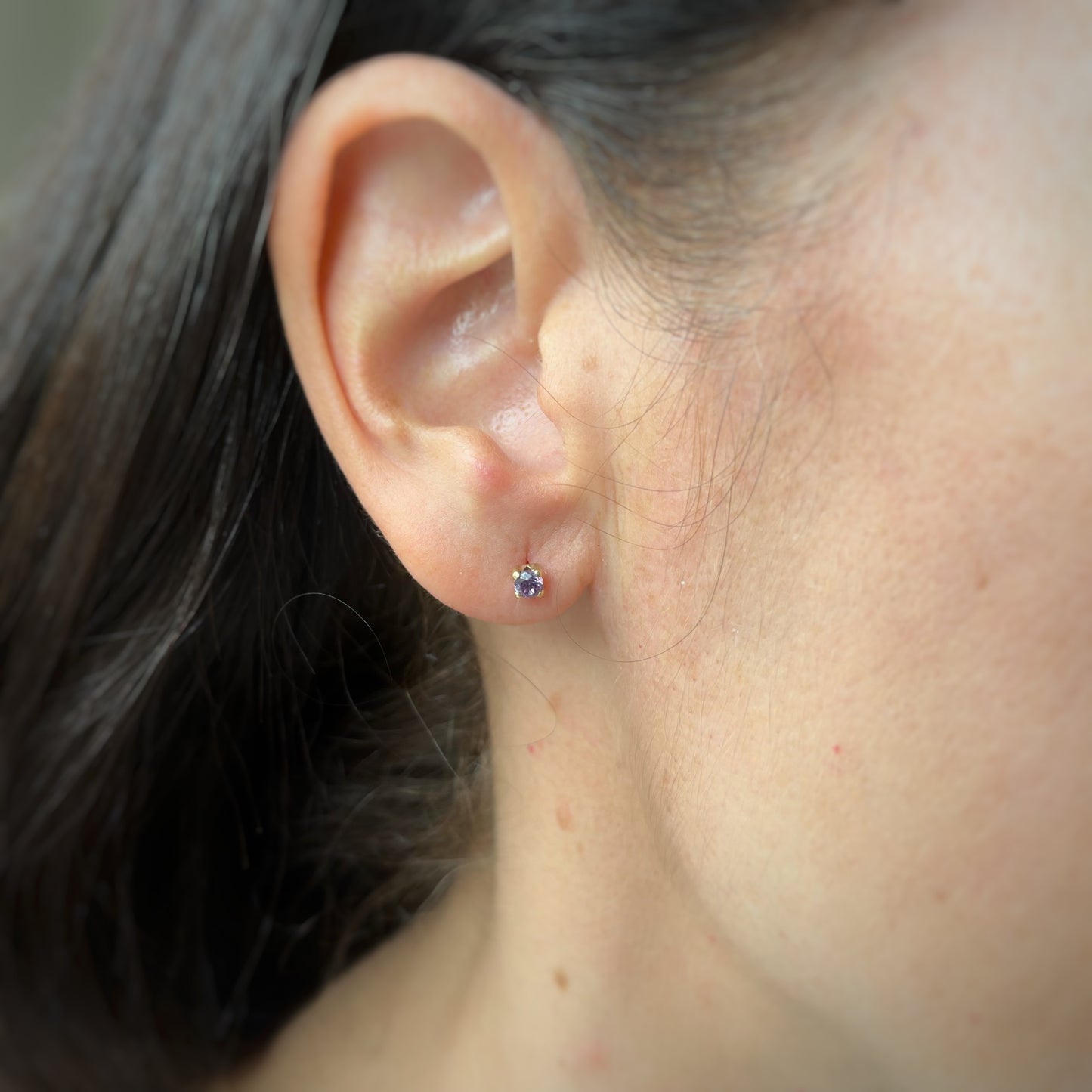 Aretes en oro amarillo 14k con circonita morada con broche rosca