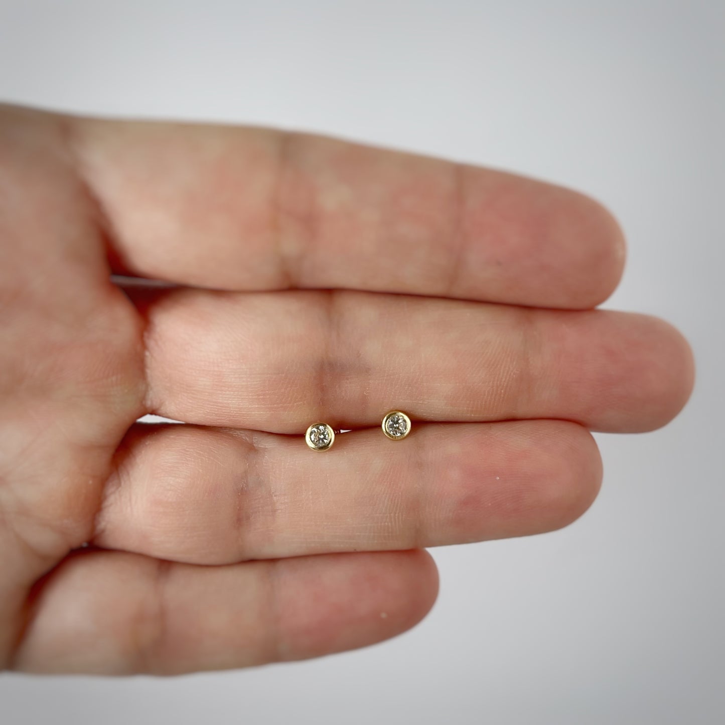 Aretes en oro amarillo 14k con circón biselado blanco con broche rosca