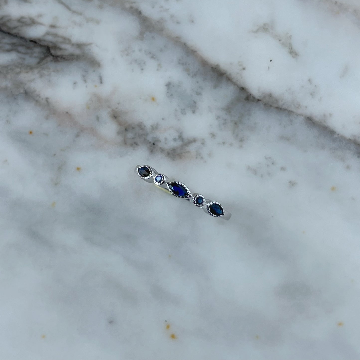 Anillo en oro blanco 10k con zafiros, marquesas y redondas