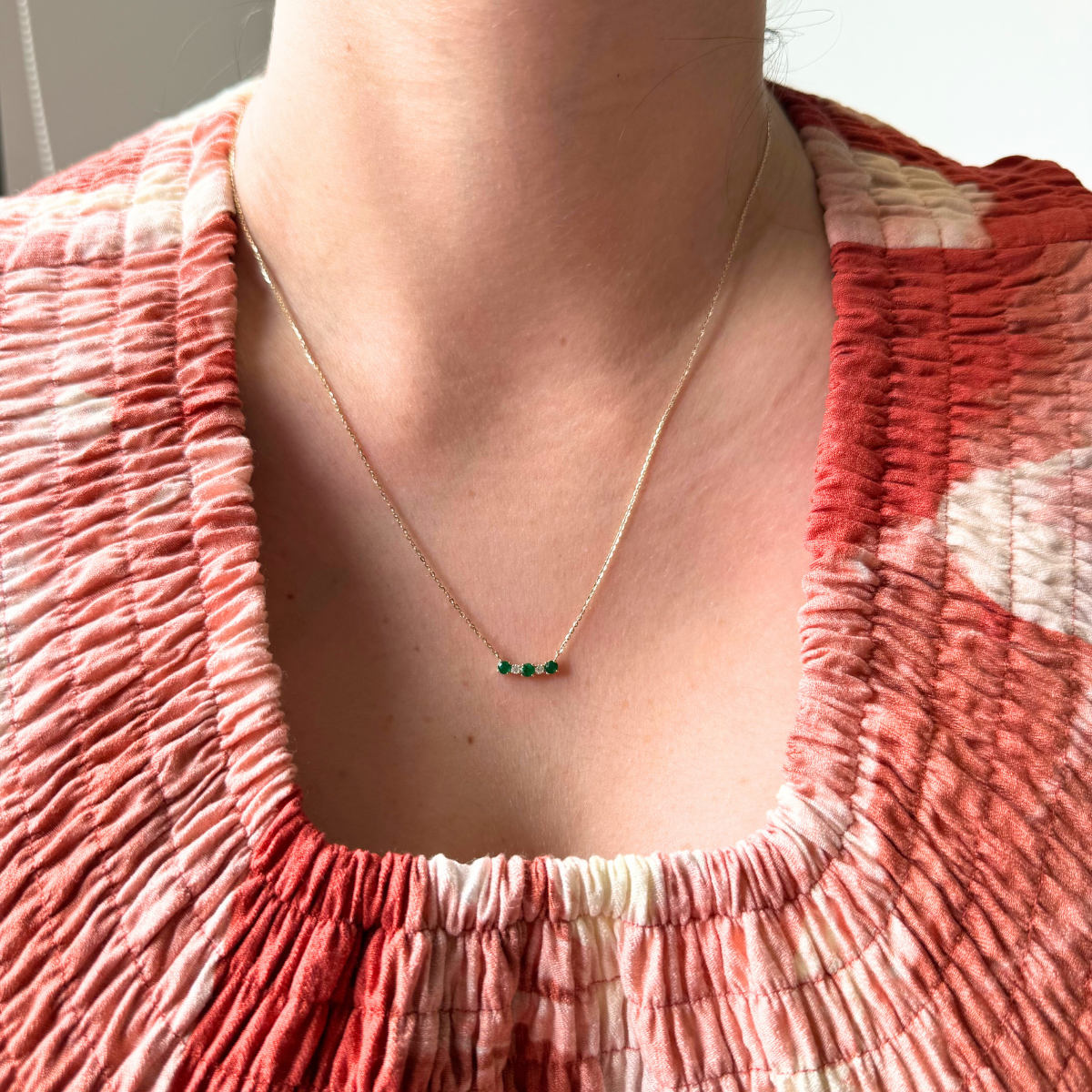 Collar en oro amarillo 14K con mini curva de esmeraldas y diamantes 0.05ctw