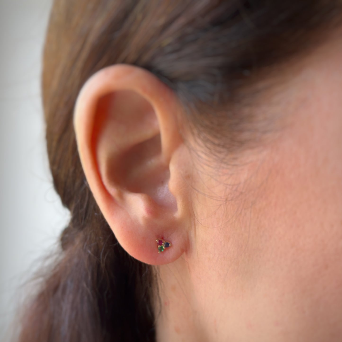 Aretes tres circonitas de color fucsia, azul y verde en oro amarillo de 14k con tope rosca