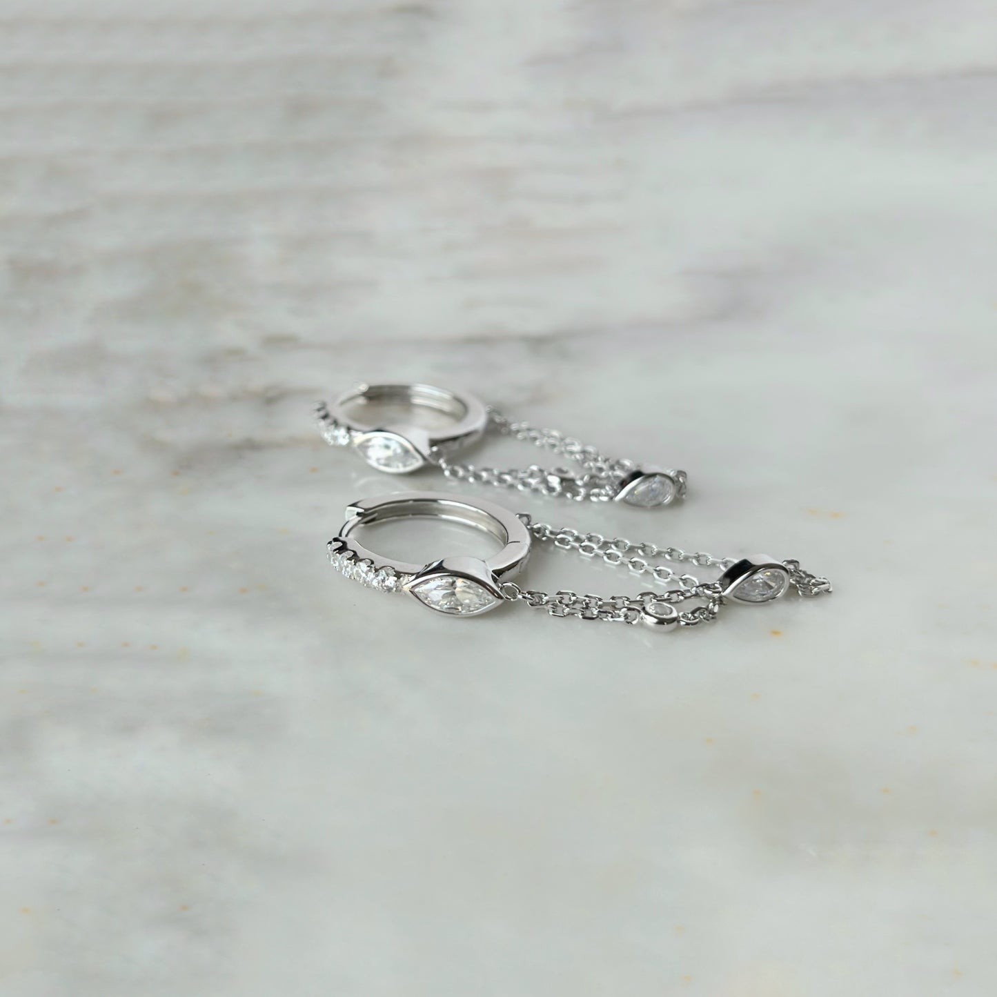 Argollas de plata con baño platino y circonita blanca con cadena y circonitas colgantes
