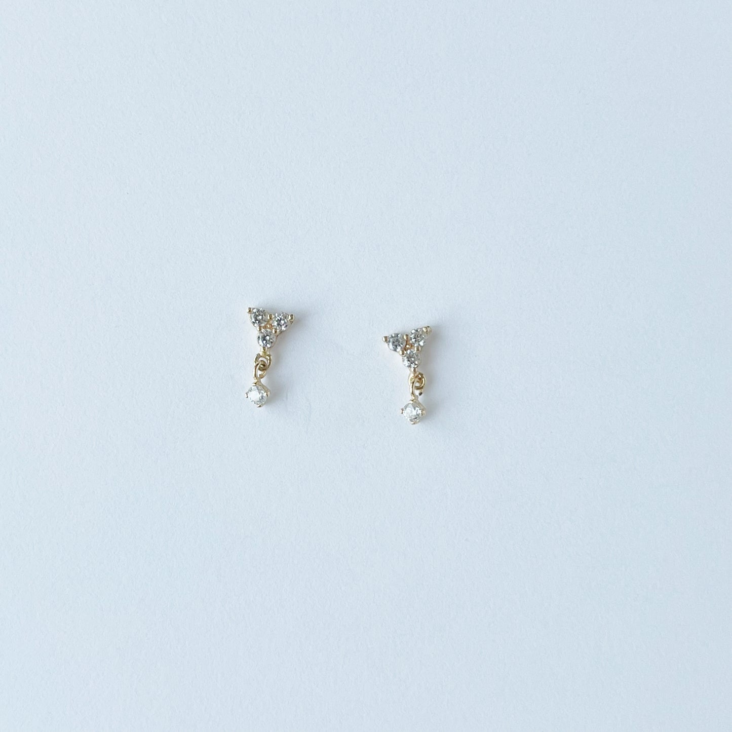 Arete single con tres circonitas blancas y una circonita colgante en oro amarillo de 14K con tope rosca