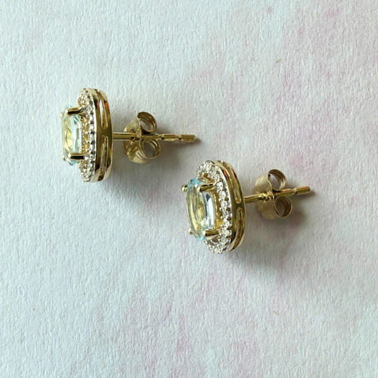 Aretes en oro amarillo 14k con aquamarina ovalada y halo de diamantes 0.18ctw