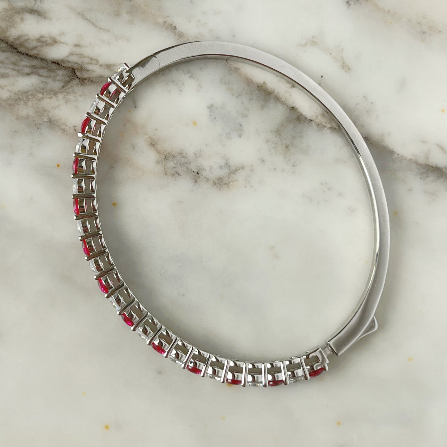 Pulsera dura de plata con baño platino y circonita blancas y rojo rubí