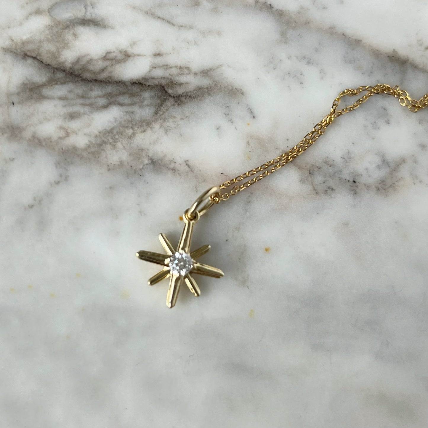 Collar en oro amarillo 10k con dije de estrella polar con diamante 0.11
