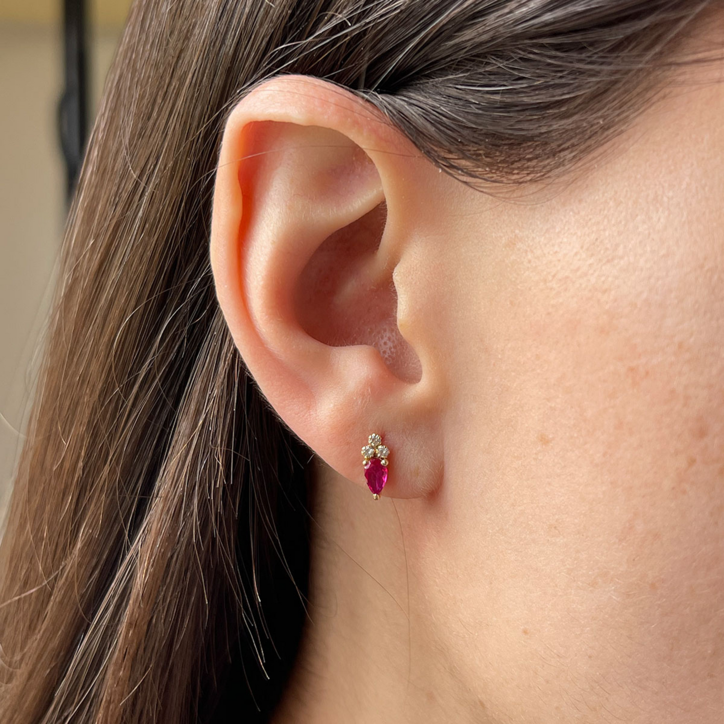 Aretes en oro amarillo 14k con circonita roja corte pera y 3 circonitas blancas y tope tornillo