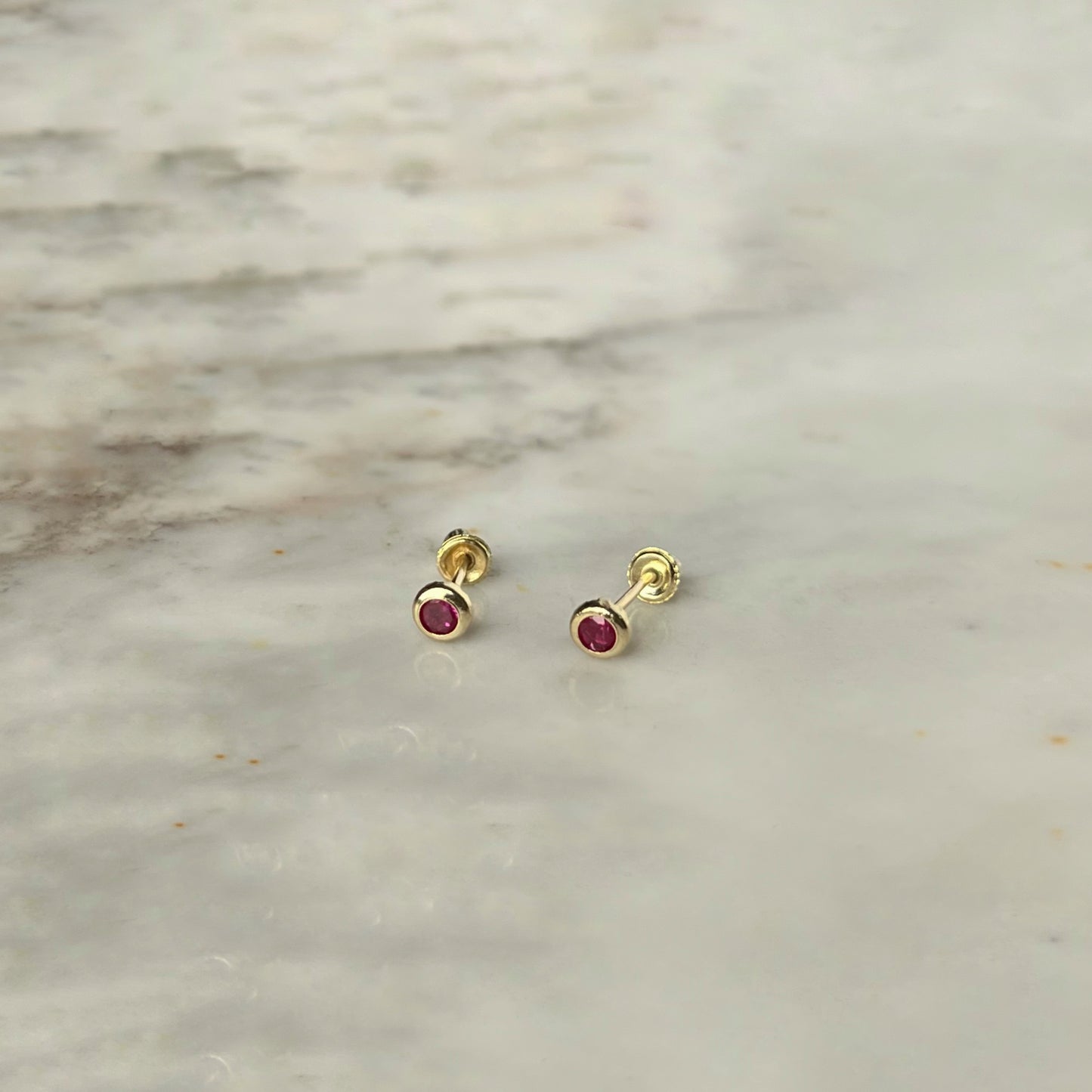 Aretes en oro amarillo 14k con circón biselado rojo con broche rosca
